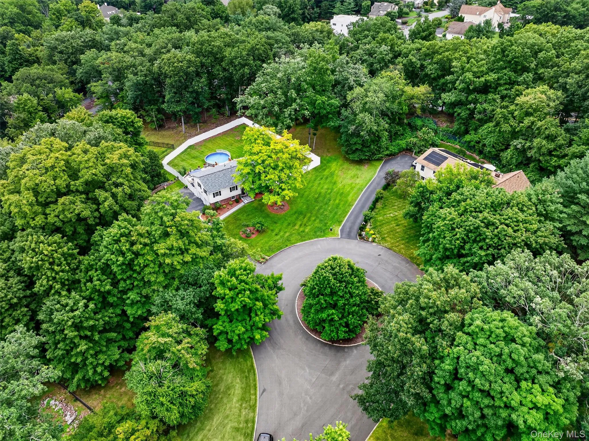 Manicured grounds with mature trees and a fenced-in above-ground pool Manicured grounds with mature trees and a fenced-in above-ground pool
