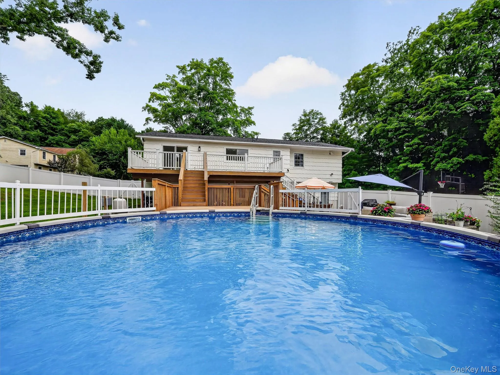 Above-ground swimming pool with a surrounding white fence Above-ground swimming pool with a surrounding white fence