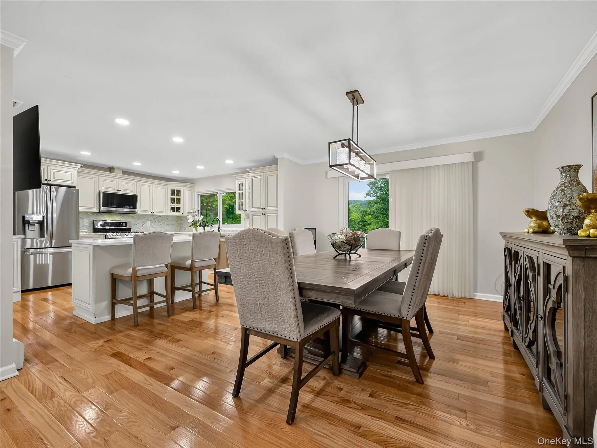 Hardwood flooring, crown molding, recessed lighting, and a contemporary linear chandelier illuminate the space Hardwood flooring, crown molding, recessed lighting, and a contemporary linear chandelier illuminate the space