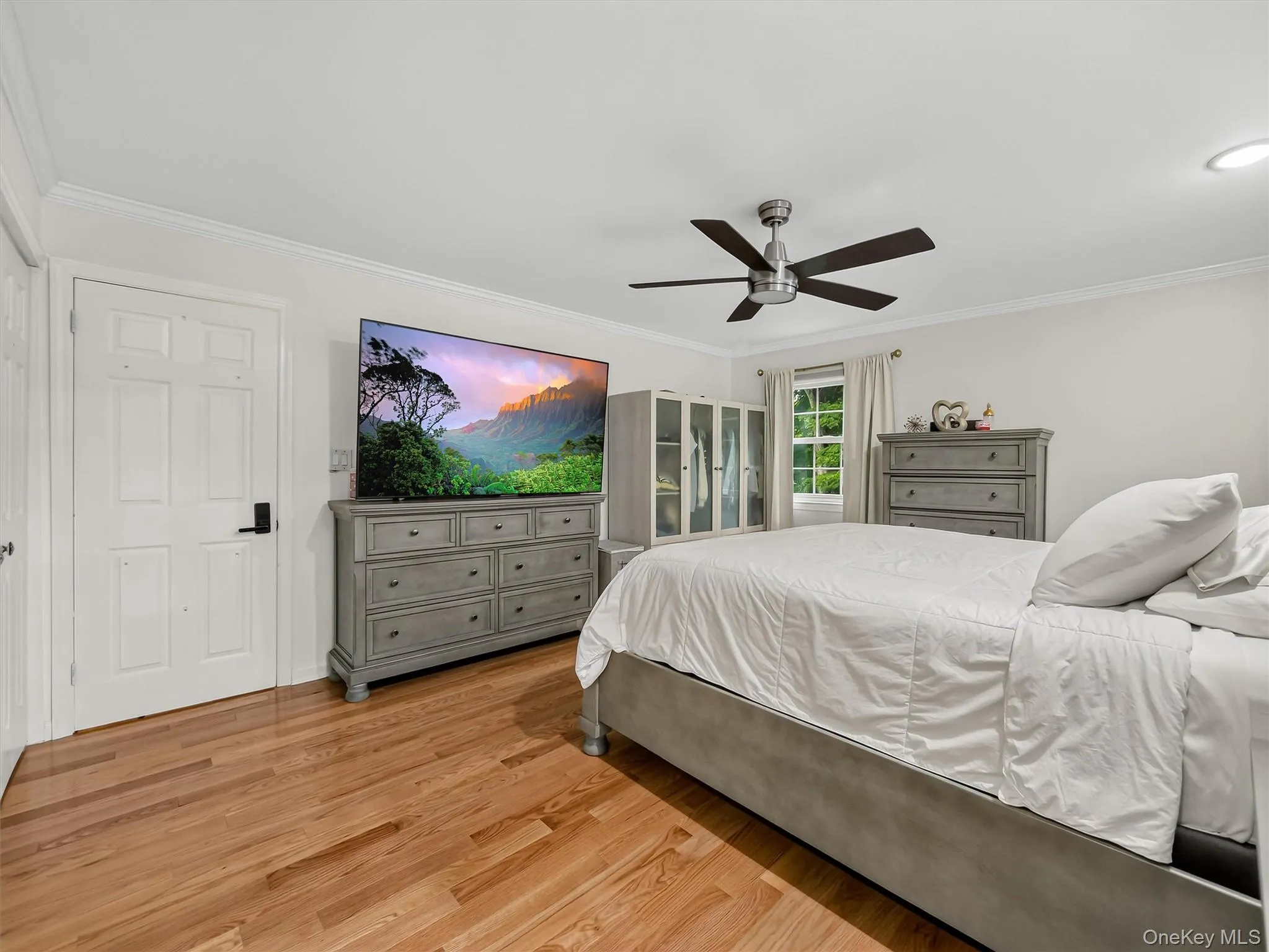Hardwood flooring, crown molding, a ceiling fan with integrated lighting, and recessed lighting Hardwood flooring, crown molding, a ceiling fan with integrated lighting, and recessed lighting