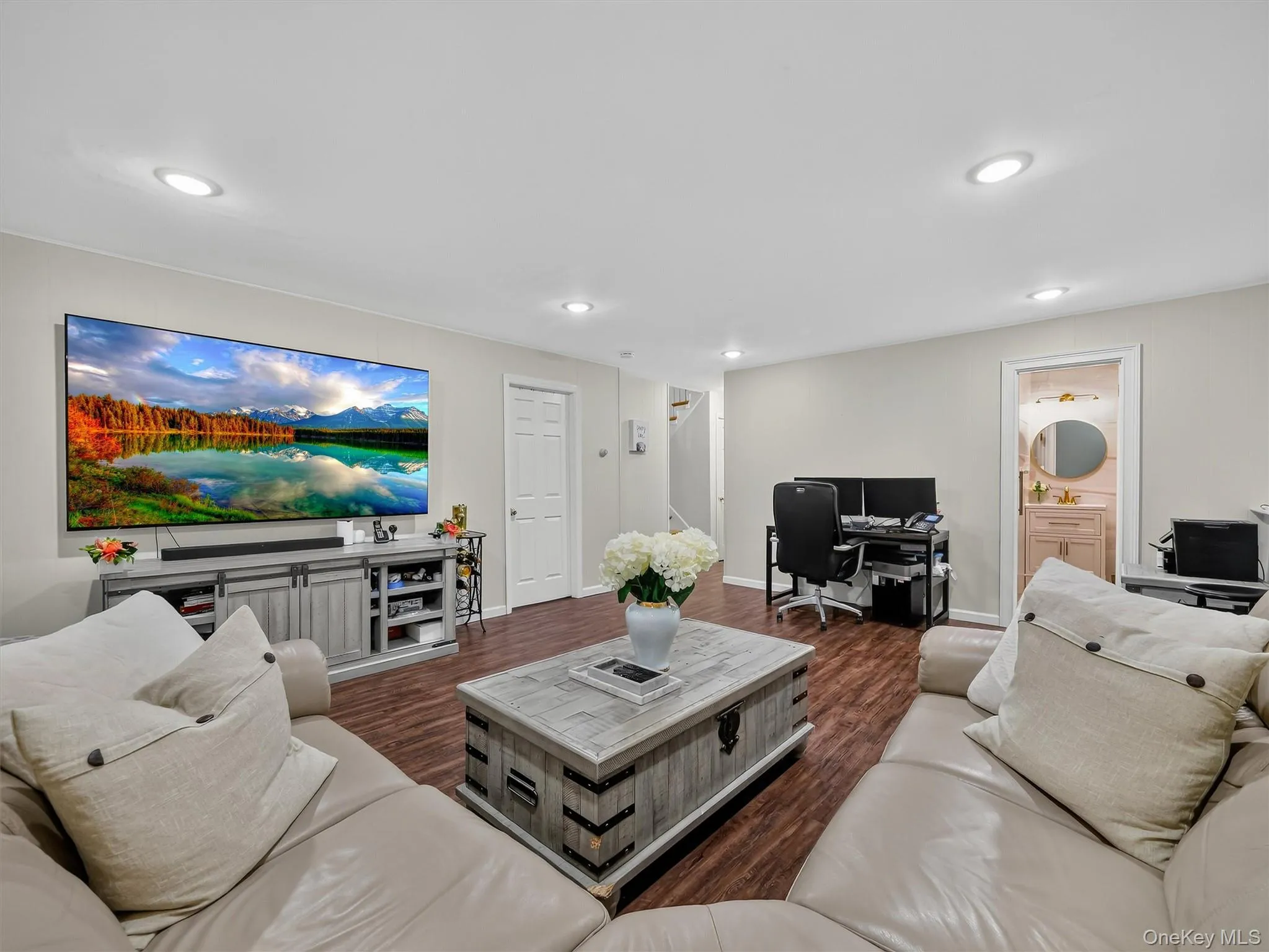 Recessed lighting, wood-finish flooring, light-toned walls, and a visible bathroom with a vanity Recessed lighting, wood-finish flooring, light-toned walls, and a visible bathroom with a vanity