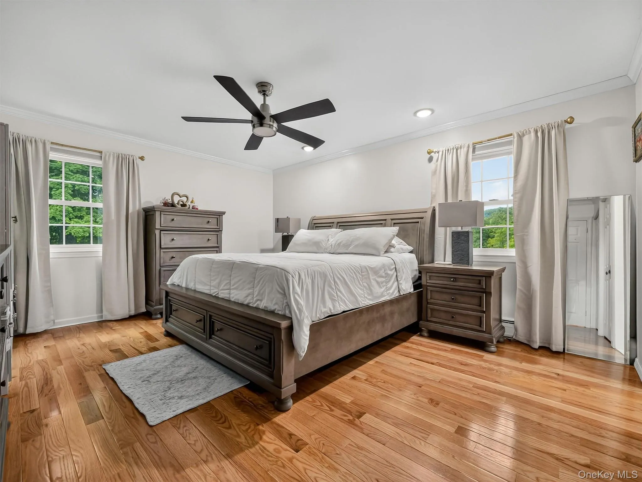 Hardwood flooring, recessed lighting, ceiling fan, crown molding, and two double-hung windows Hardwood flooring, recessed lighting, ceiling fan, crown molding, and two double-hung windows