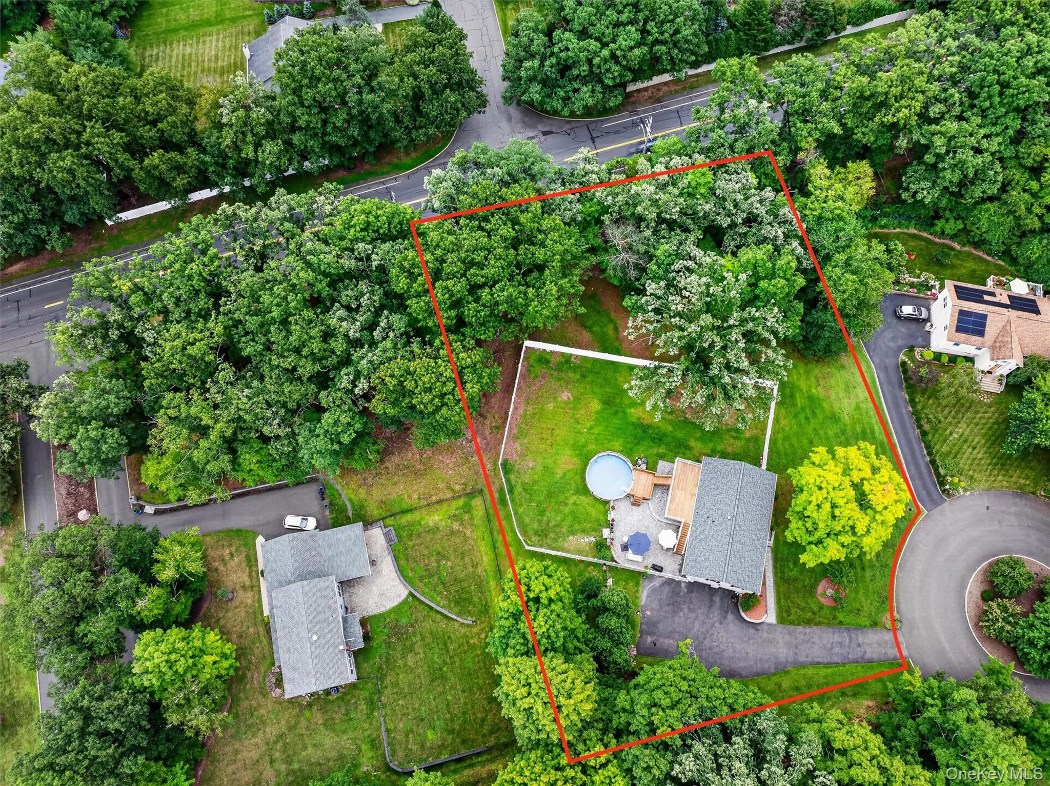 Expansive lot with mature trees, a private driveway, a paved patio, and a fenced yard Expansive lot with mature trees, a private driveway, a paved patio, and a fenced yard