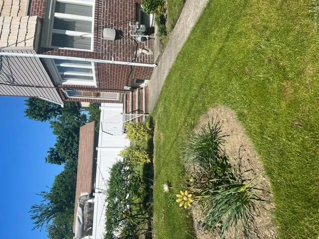 Brick exterior with white vinyl siding accents, multiple windows, and a paved walkway Brick exterior with white vinyl siding accents, multiple windows, and a paved walkway