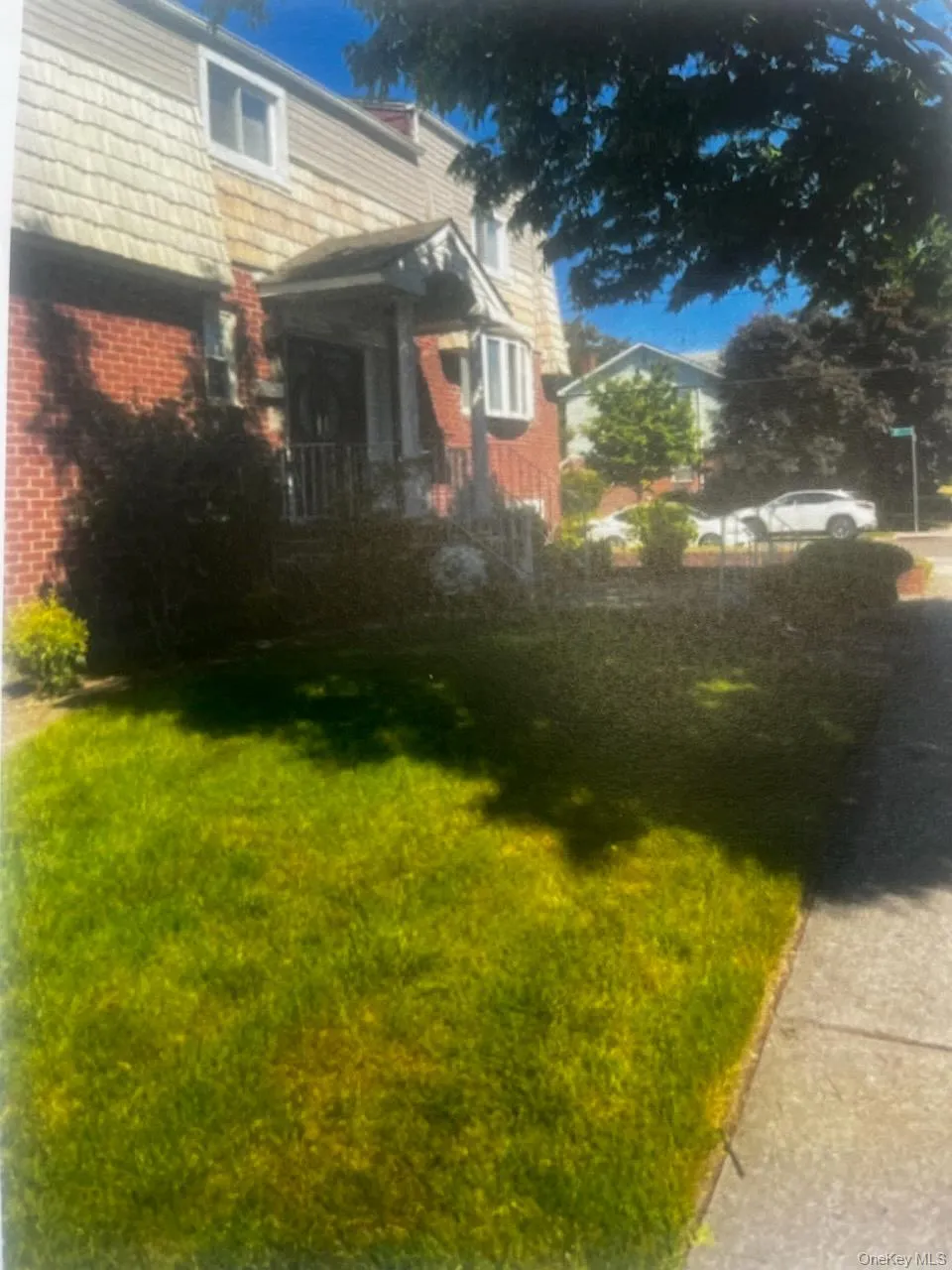 Brick and shingle exterior with a covered entry, bay window, and front lawn Brick and shingle exterior with a covered entry, bay window, and front lawn