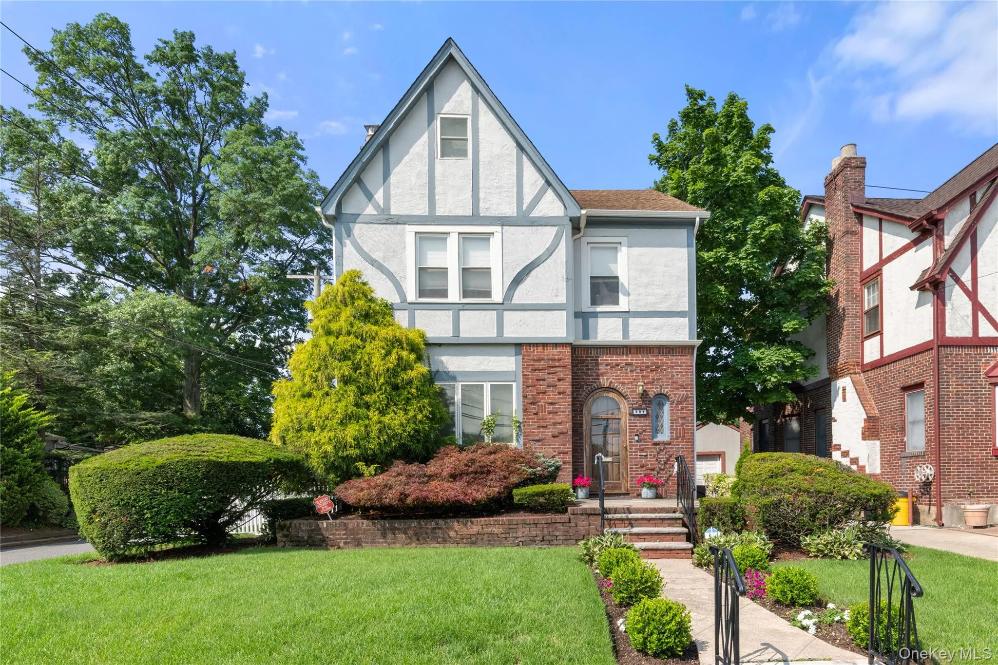 Tudor-style facade featuring brick and stucco with decorative timber detailing Tudor-style facade featuring brick and stucco with decorative timber detailing