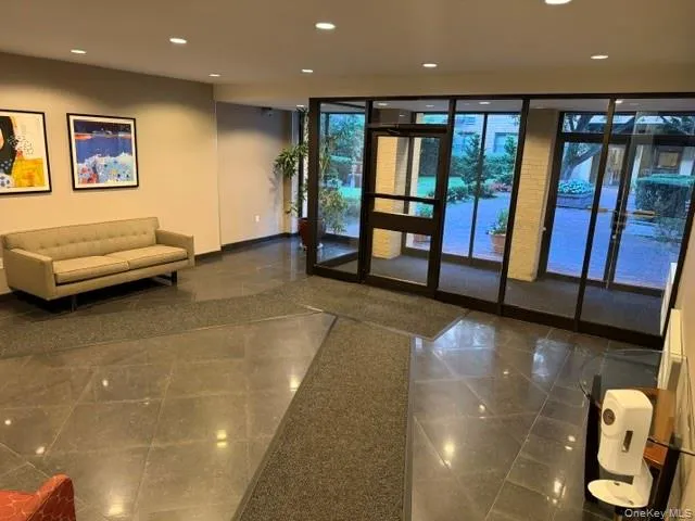 Lobby area featuring large format tile flooring, recessed lighting, and a glass-paneled exterior wall Lobby area featuring large format tile flooring, recessed lighting, and a glass-paneled exterior wall