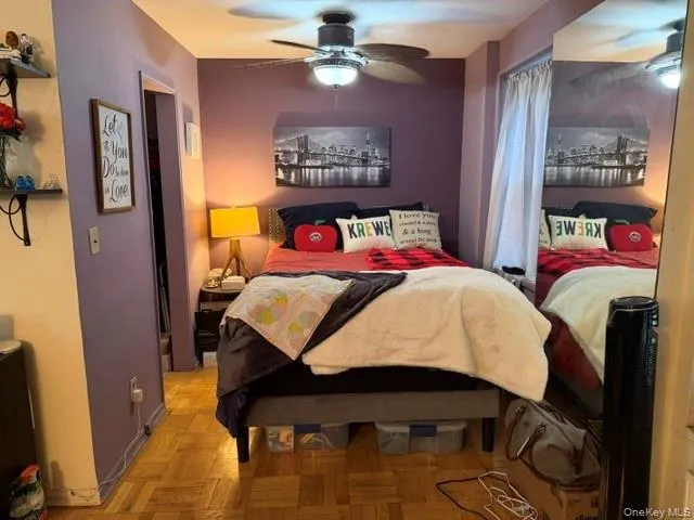 Sleeping Alcove with Parquet wood-finish flooring, ceiling fan with integrated lighting, built-in shelving, and a full-height mirror Sleeping Alcove with Parquet wood-finish flooring, ceiling fan with integrated lighting, built-in shelving, and a full-height mirror