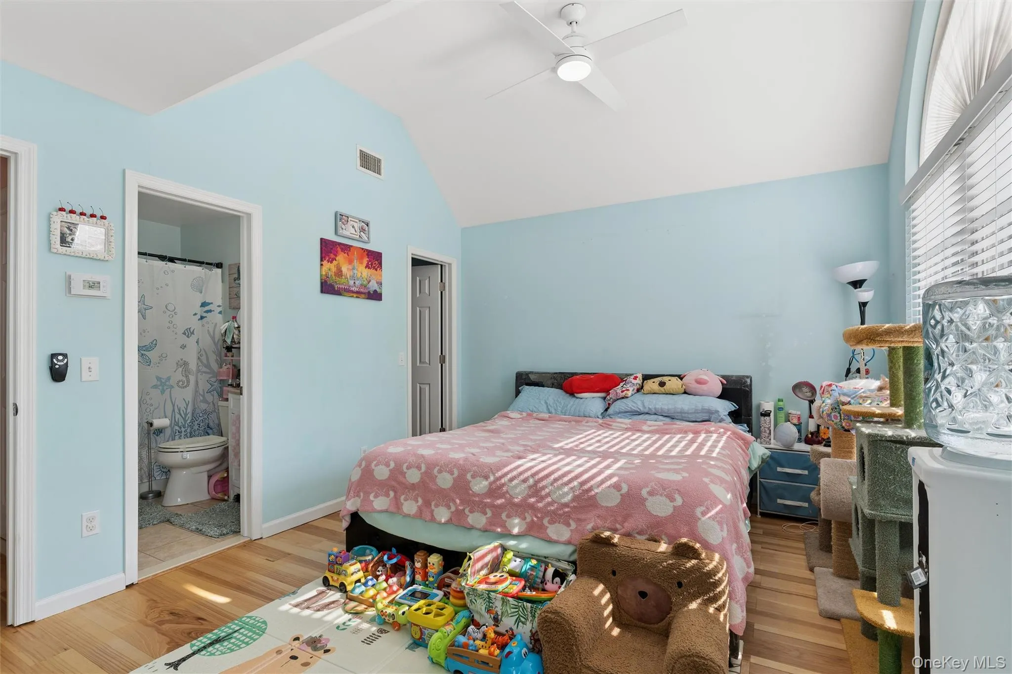 Vaulted ceiling with a ceiling fan, light-toned wood-finish flooring, and a window with blinds Vaulted ceiling with a ceiling fan, light-toned wood-finish flooring, and a window with blinds