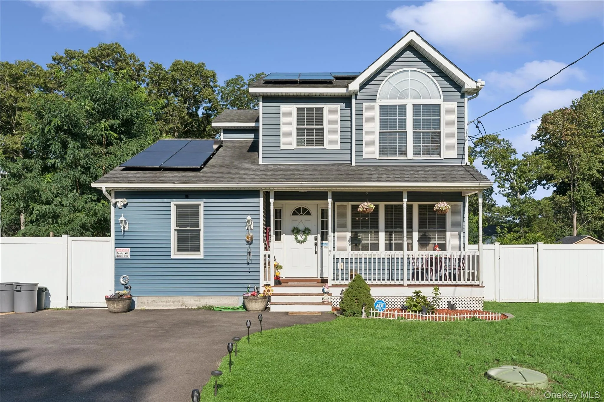 Blue siding exterior with a covered front porch, white railing, and decorative shutters Blue siding exterior with a covered front porch, white railing, and decorative shutters