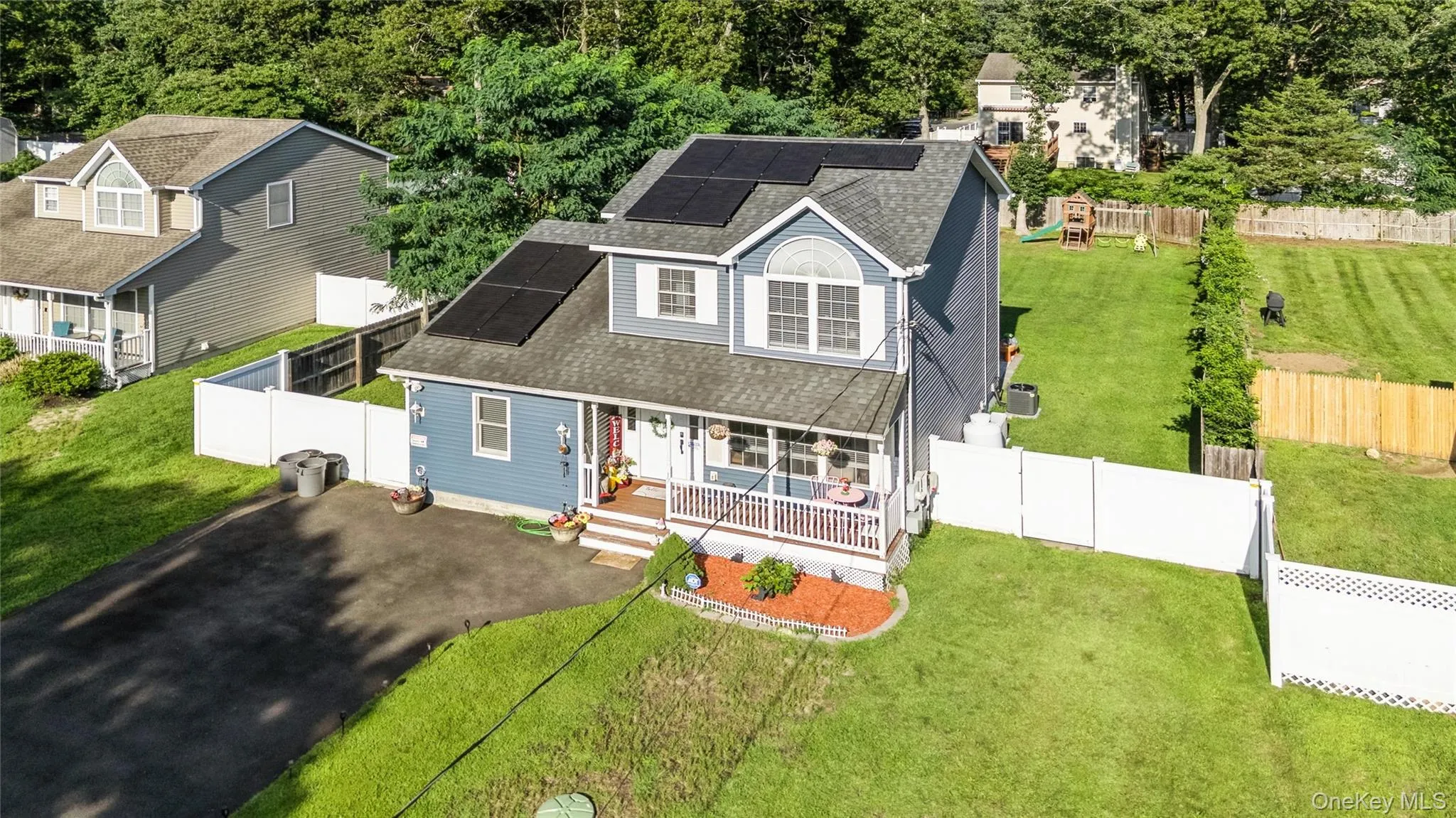 Two-story residence featuring a covered front porch, solar panels, and a gabled dormer Two-story residence featuring a covered front porch, solar panels, and a gabled dormer
