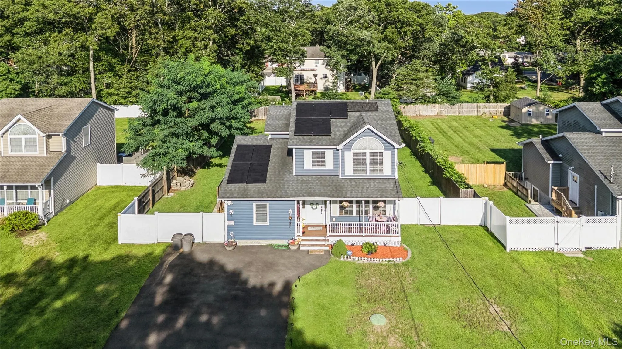 Two-story residence featuring a covered front porch, solar panels, and a gabled dormer Two-story residence featuring a covered front porch, solar panels, and a gabled dormer