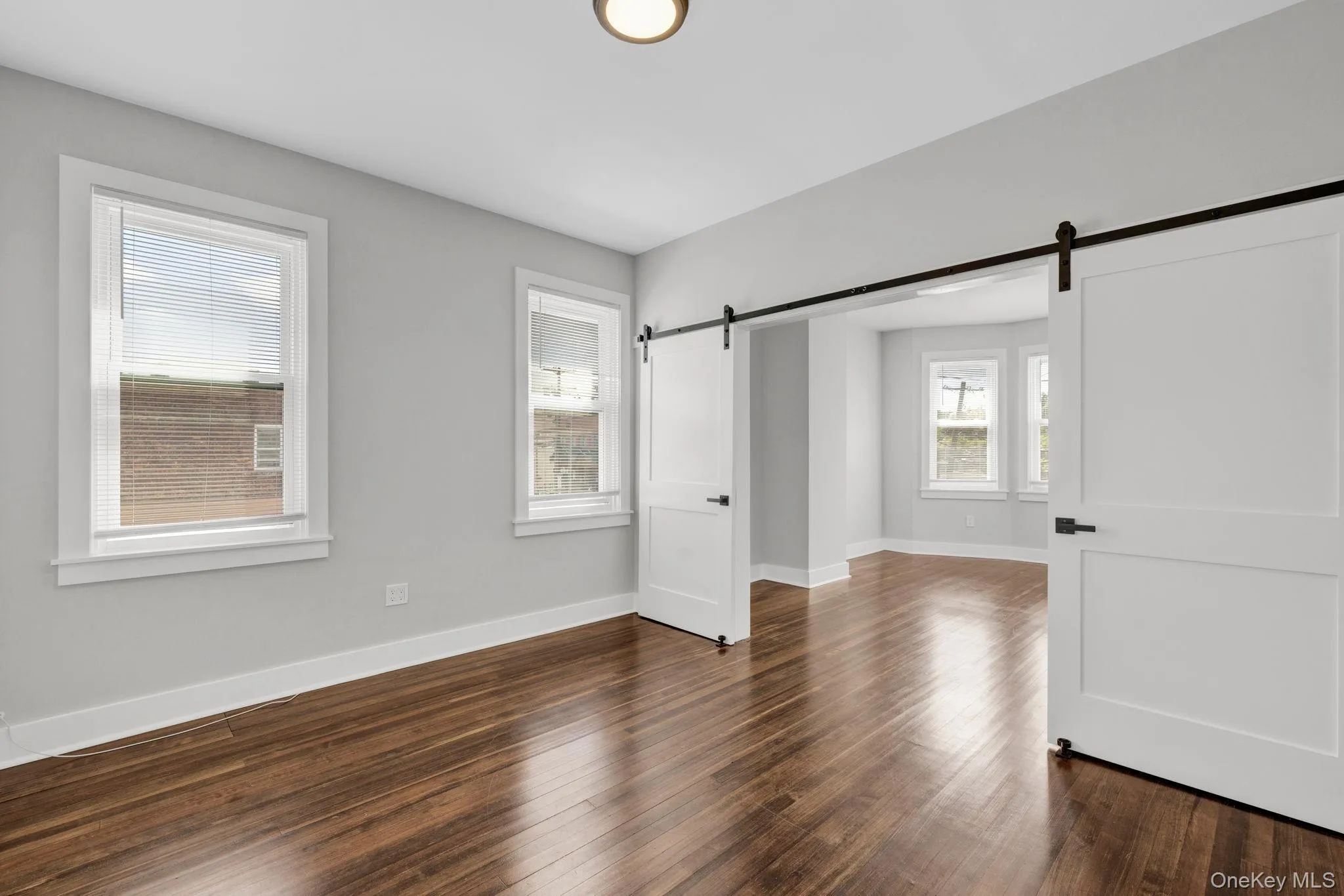 Entry into living room with barn doors into Primary bedroom before built in closet was constructed Entry into living room with barn doors into Primary bedroom before built in closet was constructed