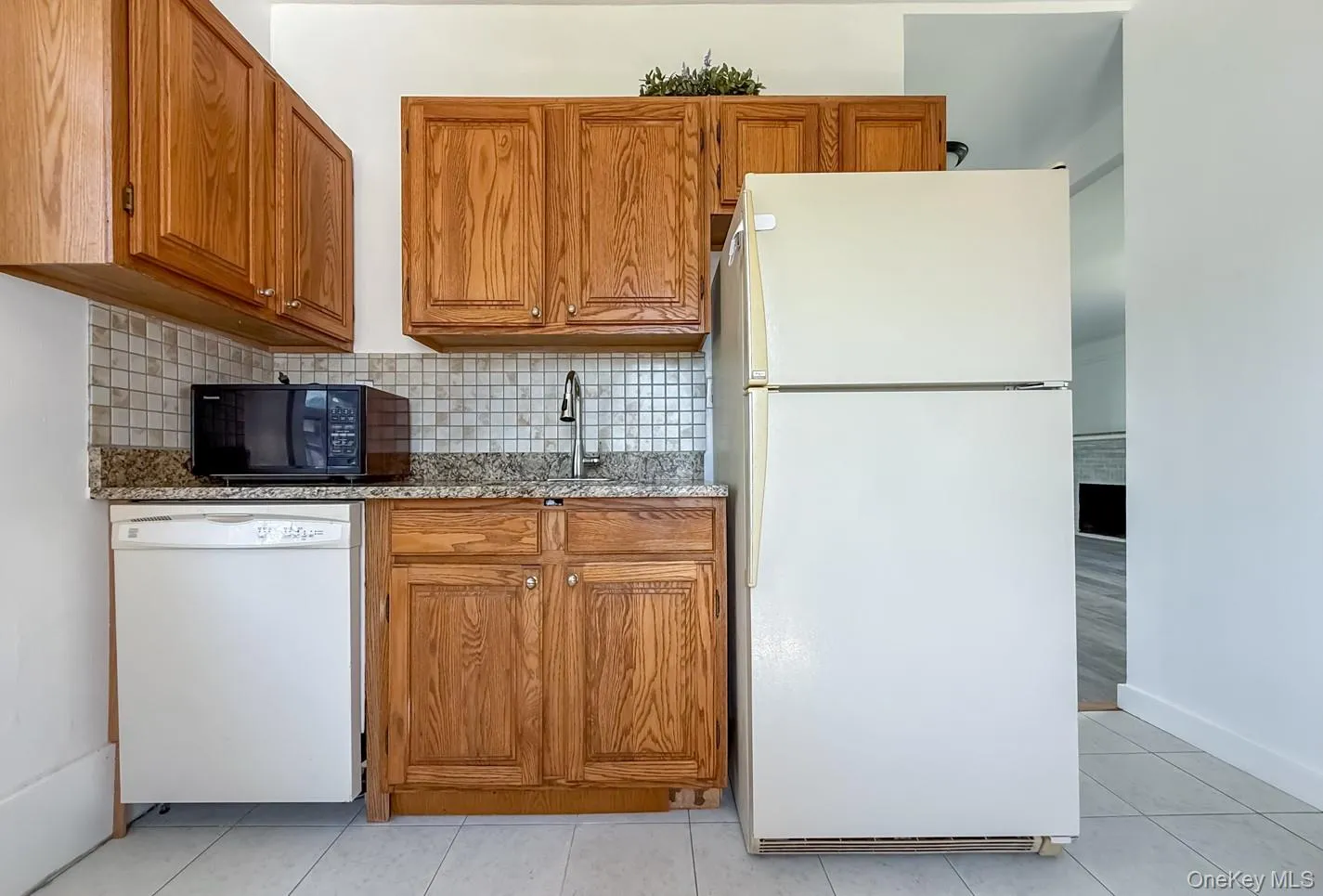 Solid wood cabinetry, granite countertops, mosaic tile backsplash, full-size refrigerator, and integrated dishwasher Solid wood cabinetry, granite countertops, mosaic tile backsplash, full-size refrigerator, and integrated dishwasher