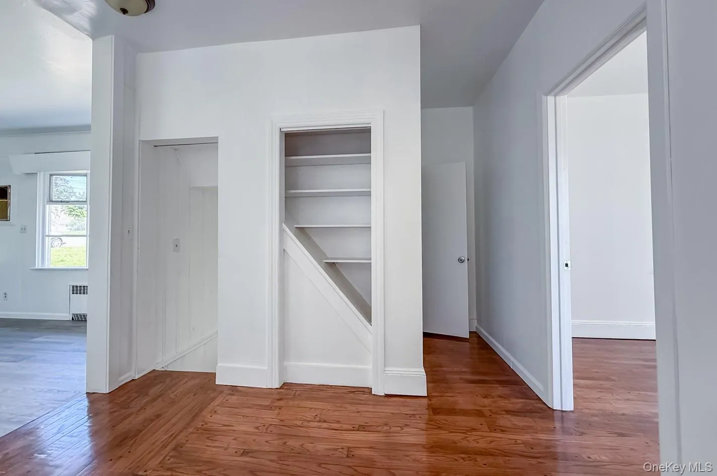 Hallway by kitchen with stairs access to attic above and basement below Hallway by kitchen with stairs access to attic above and basement below