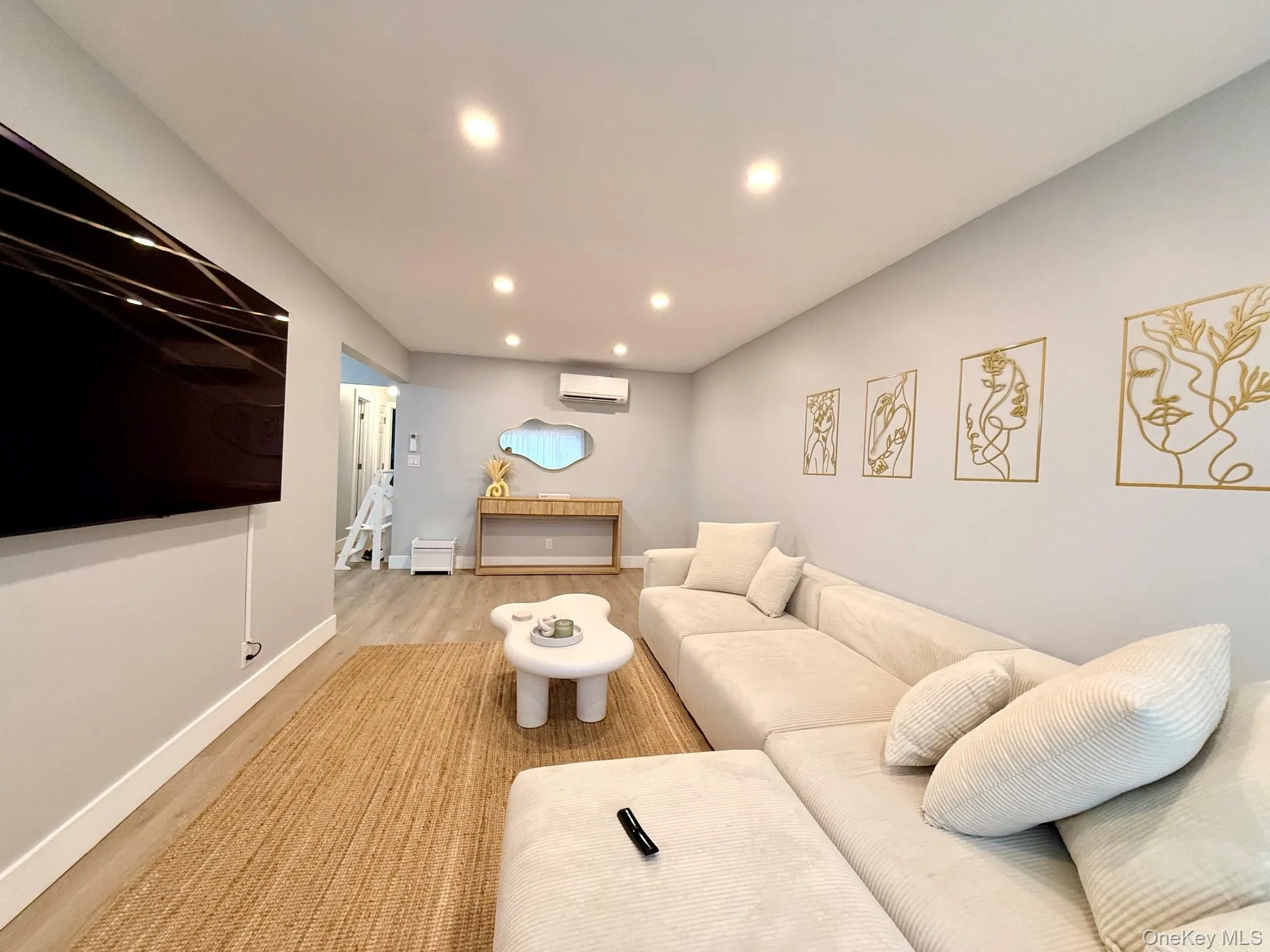 Recessed lighting illuminates wood-finish flooring throughout the space Recessed lighting illuminates wood-finish flooring throughout the space