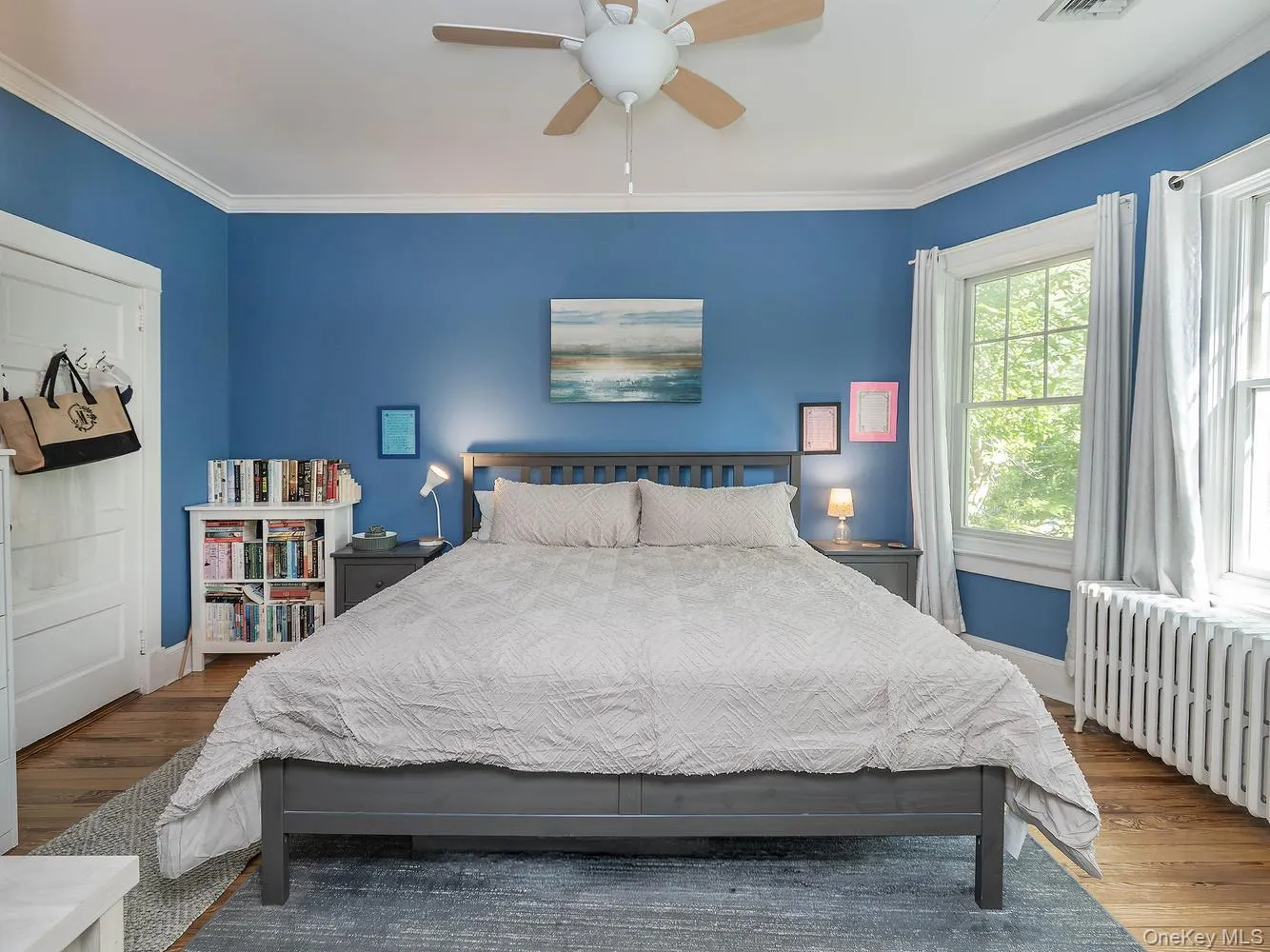 Primary bedroom is bright and inviting with wood moldings adding character throughout and a walk-in closet for ample storage Primary bedroom is bright and inviting with wood moldings adding character throughout and a walk-in closet for ample storage
