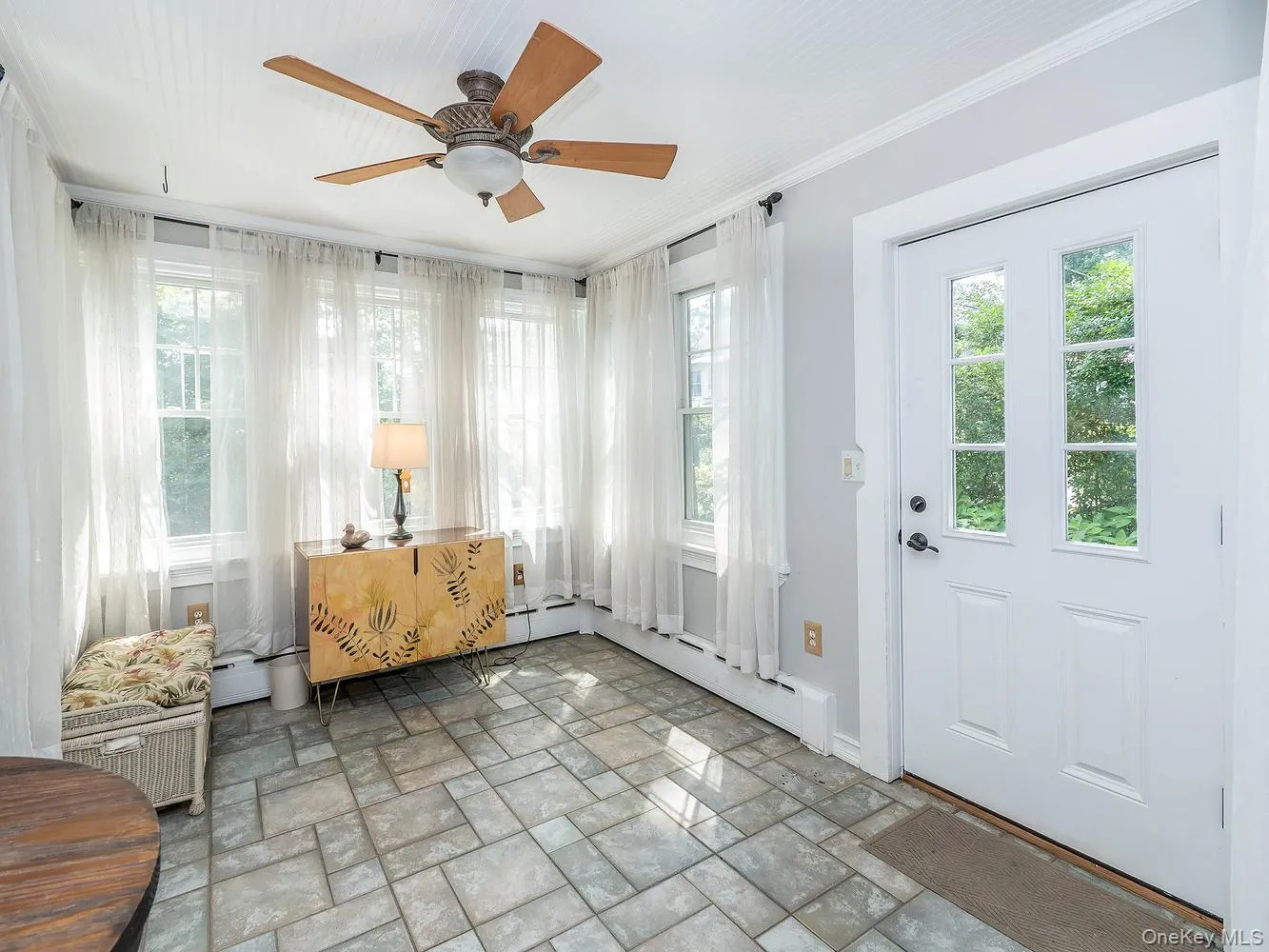 As you enter into the home, you're greeted by a large entryway with slate pavers underfoot and an abundance of windows As you enter into the home, you're greeted by a large entryway with slate pavers underfoot and an abundance of windows