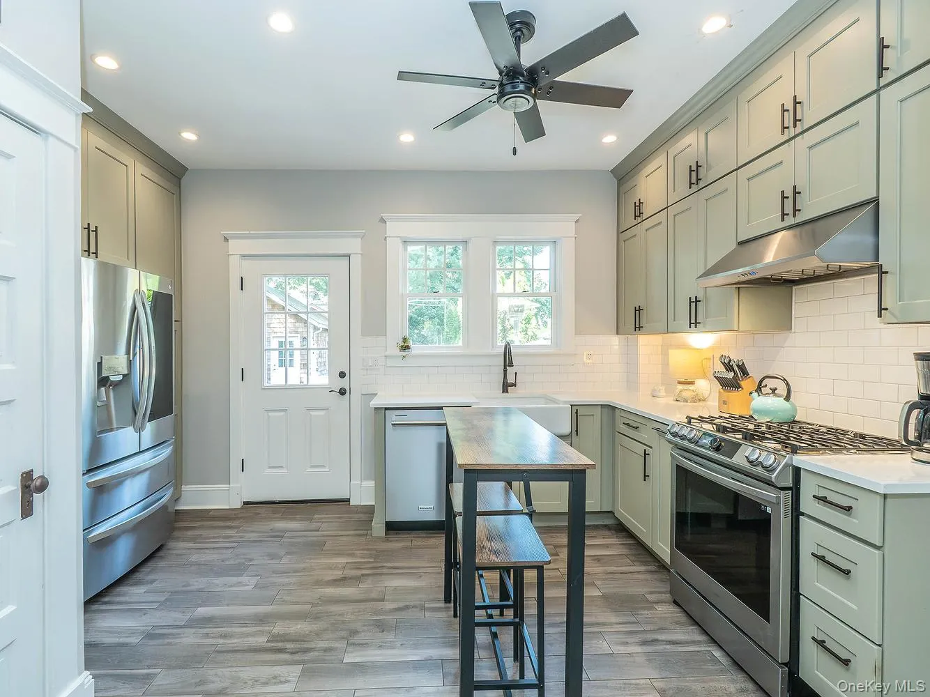 Kitchen with all stainless-steel appliances and door to back deck for easy outdoor entertaining Kitchen with all stainless-steel appliances and door to back deck for easy outdoor entertaining