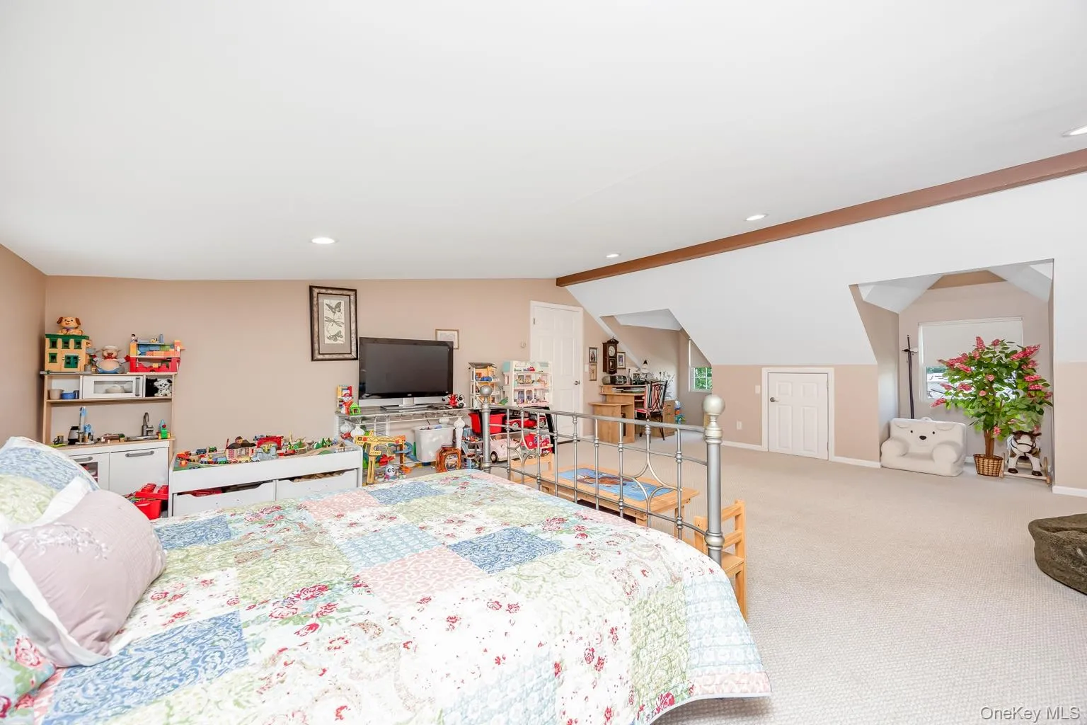 Spacious room featuring carpeting, recessed lighting, and sloped ceiling details Spacious room featuring carpeting, recessed lighting, and sloped ceiling details