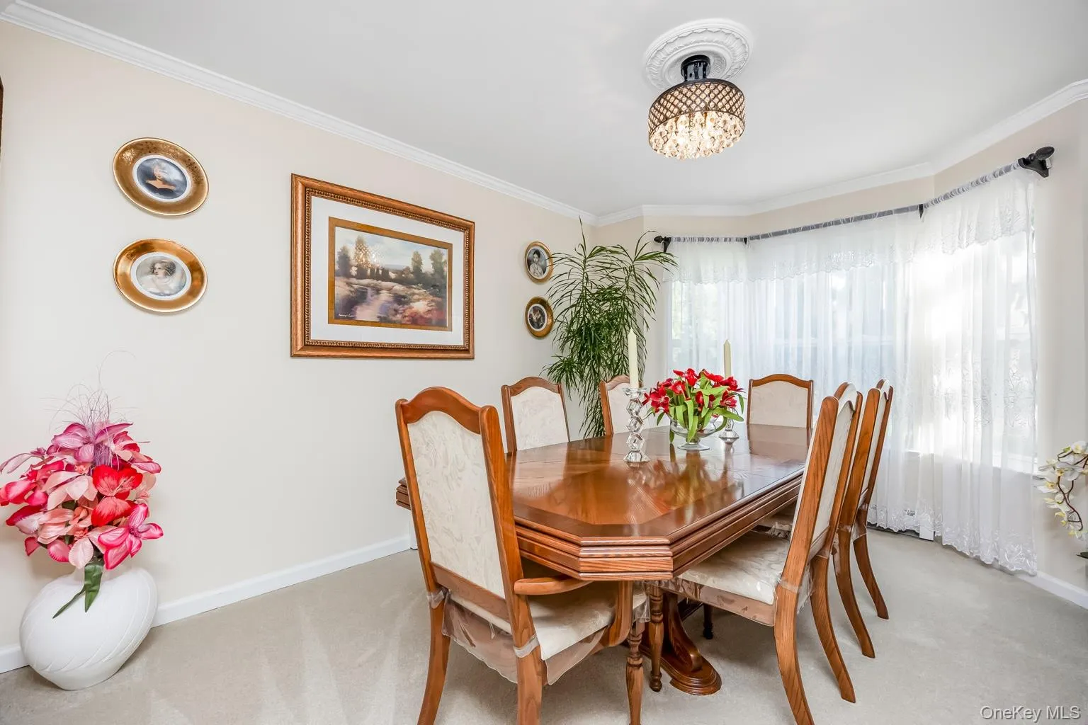 Recessed lighting fixture with decorative ceiling medallion, bay window with sheer curtains, and light neutral wall paint Recessed lighting fixture with decorative ceiling medallion, bay window with sheer curtains, and light neutral wall paint