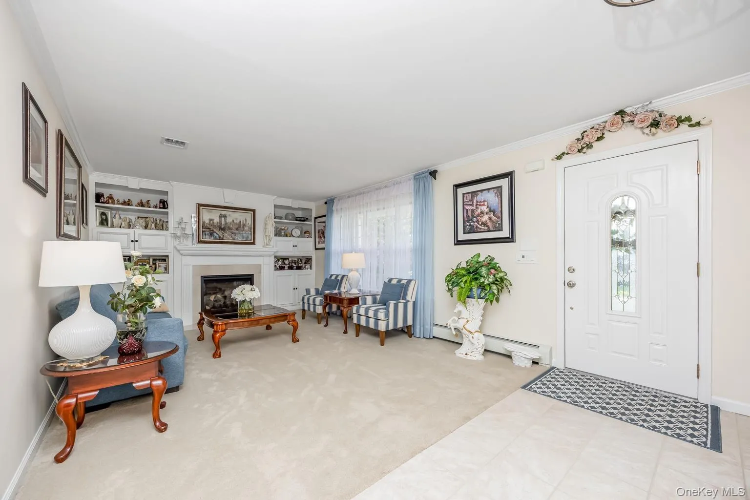 Recessed fireplace with a light-toned surround, built-in shelving, and light-toned wall-to-wall carpeting Recessed fireplace with a light-toned surround, built-in shelving, and light-toned wall-to-wall carpeting