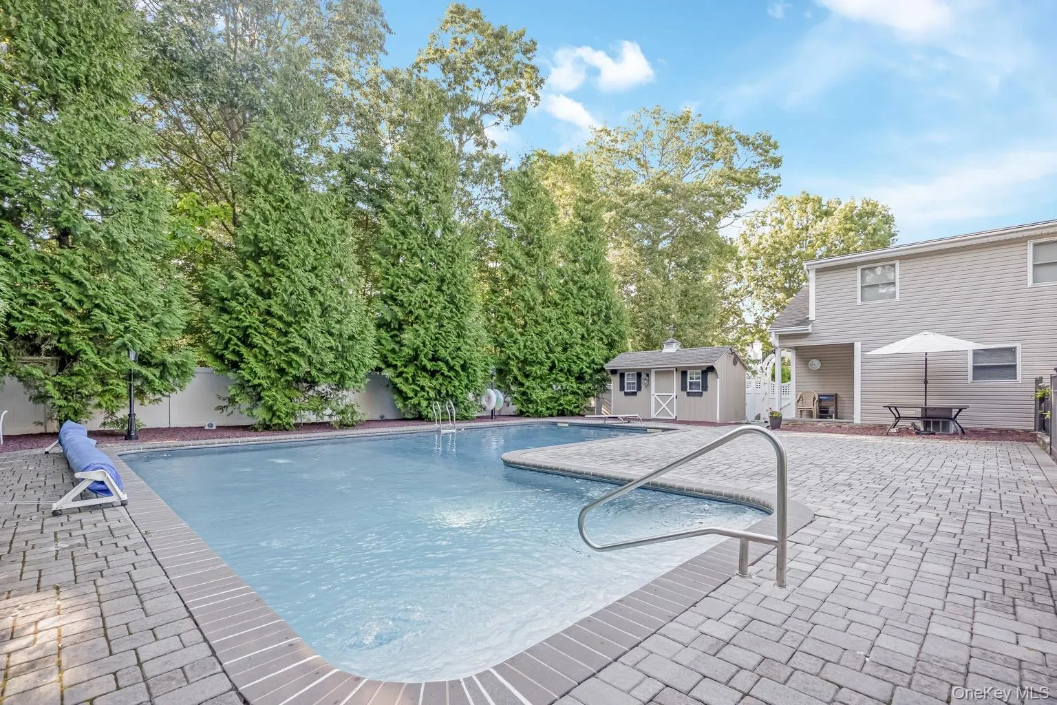 Swimming pool with brick coping and integrated steps, surrounded by stone paver patio Swimming pool with brick coping and integrated steps, surrounded by stone paver patio