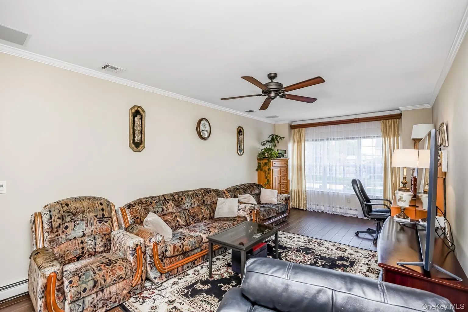 Hardwood-style flooring, crown molding, a ceiling fan, and window treatments Hardwood-style flooring, crown molding, a ceiling fan, and window treatments