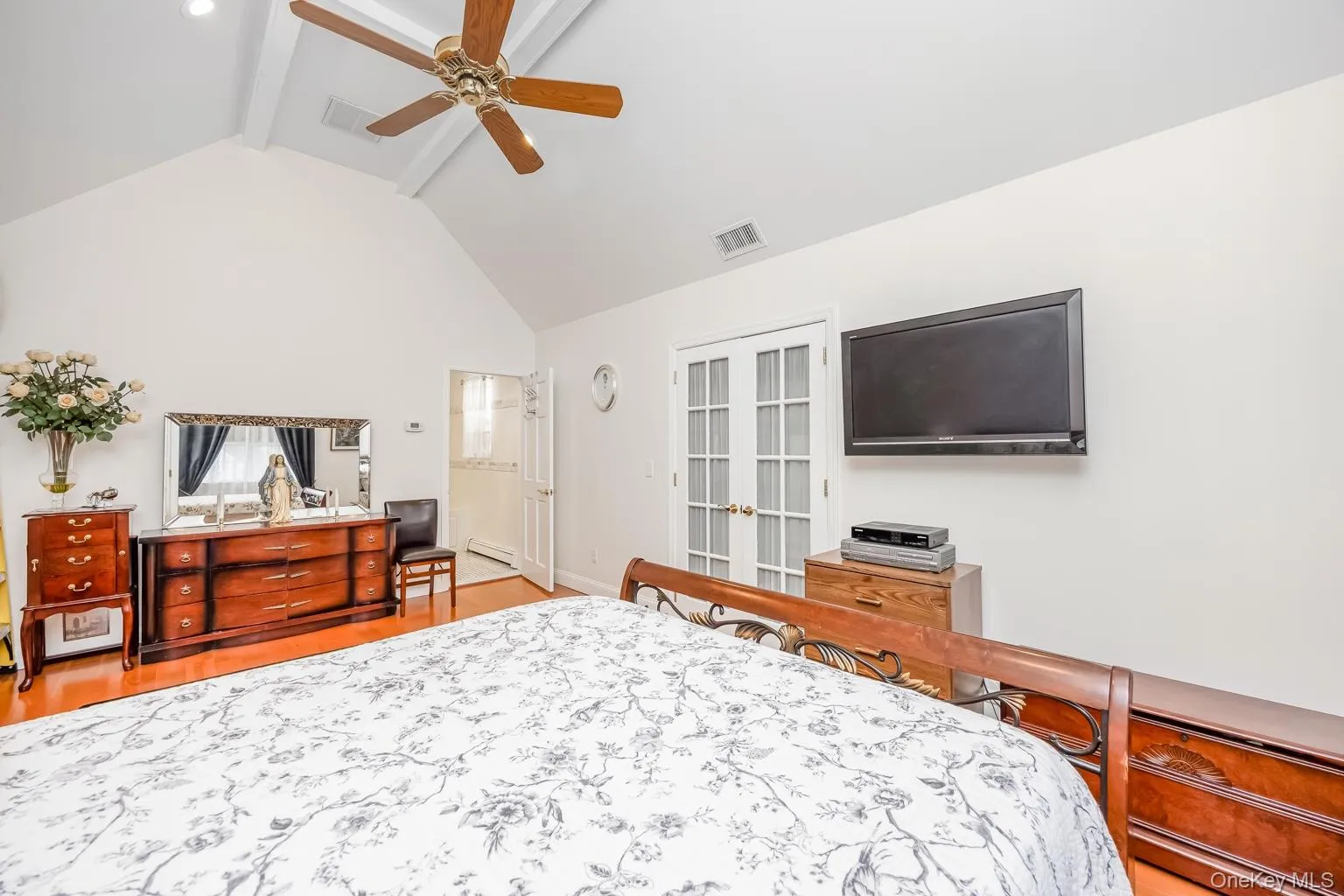 Vaulted ceiling with exposed beams, wood-finish flooring, recessed lighting, and French doors Vaulted ceiling with exposed beams, wood-finish flooring, recessed lighting, and French doors