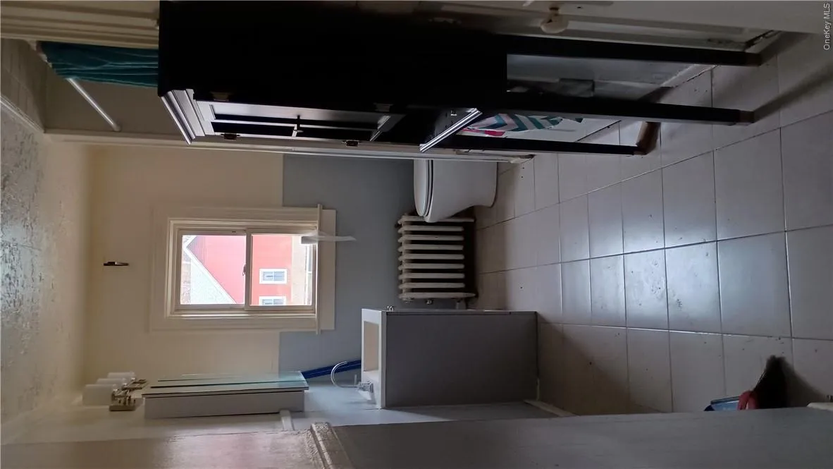 Bathroom with toilet, vanity, tile patterned floors, and radiator Bathroom with toilet, vanity, tile patterned floors, and radiator