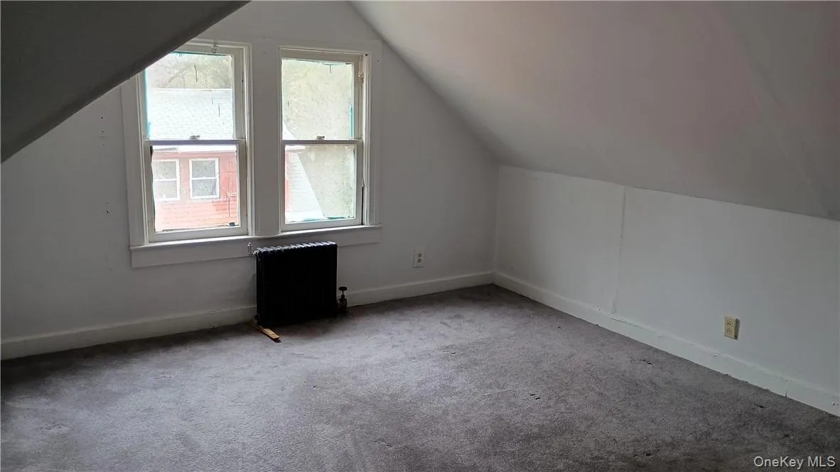 Bonus room with radiator heating unit, vaulted ceiling, and carpet Bonus room with radiator heating unit, vaulted ceiling, and carpet