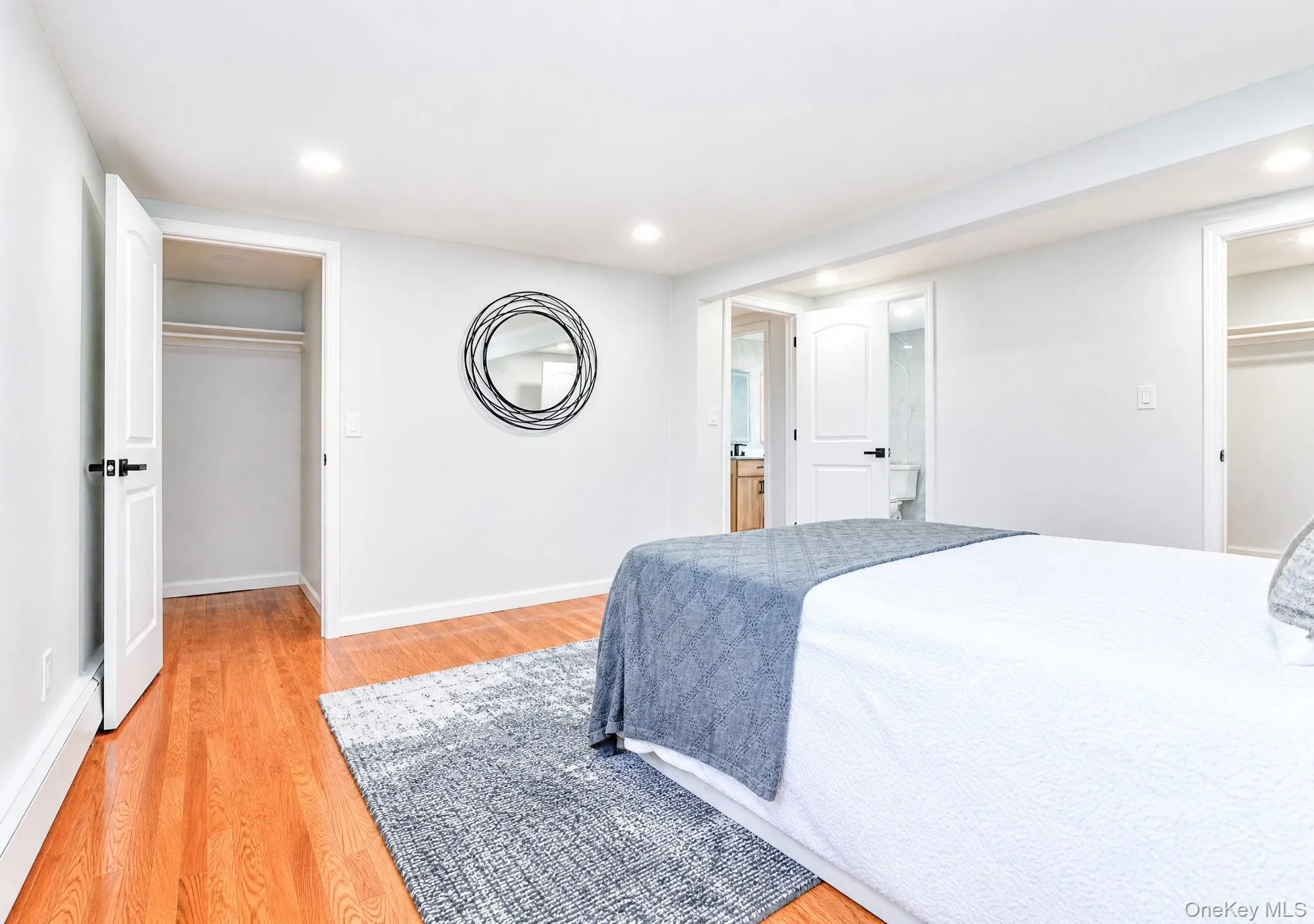 Hardwood flooring extends throughout this room, featuring recessed lighting and white baseboards Hardwood flooring extends throughout this room, featuring recessed lighting and white baseboards