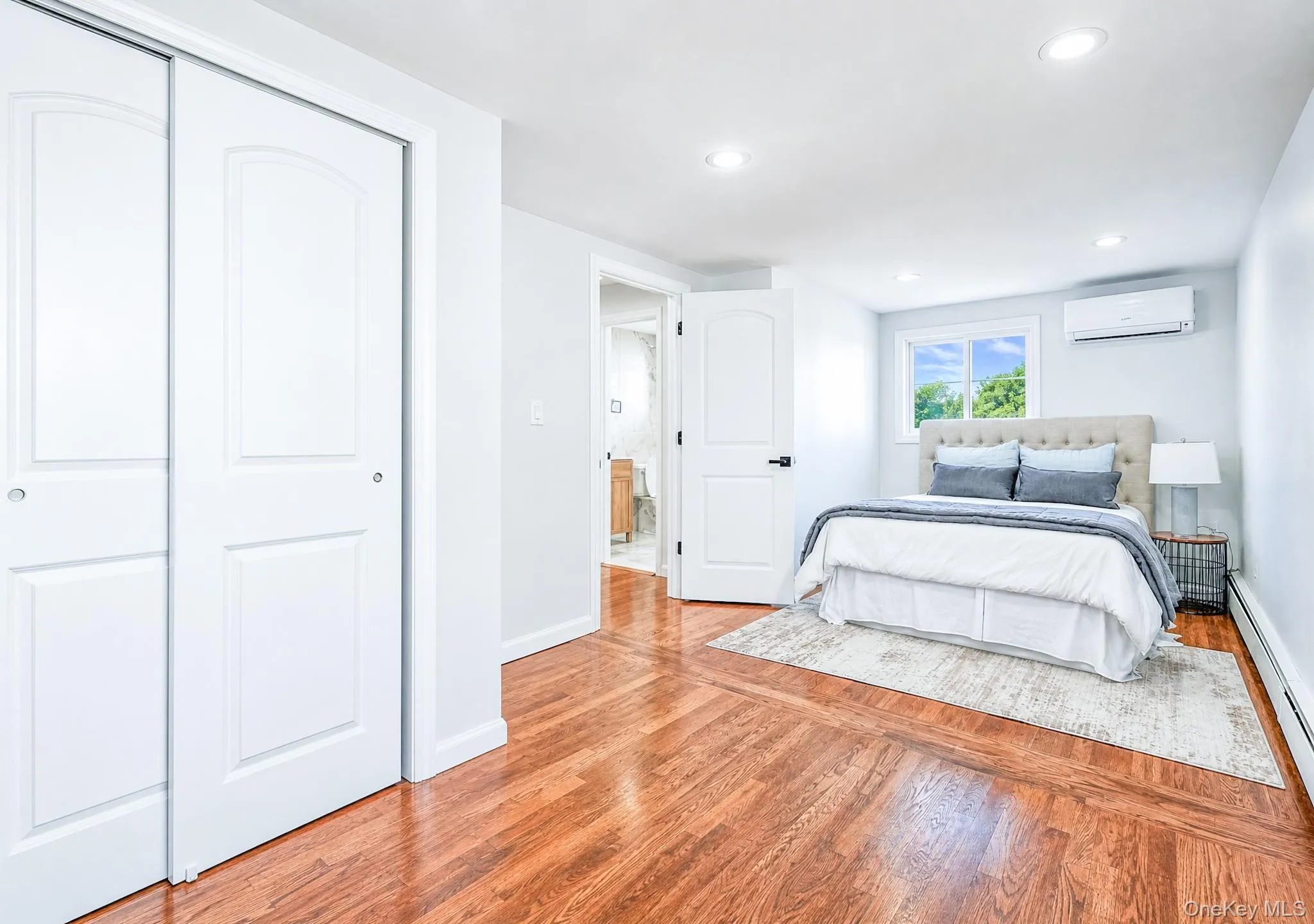 Hardwood flooring throughout featuring recessed lighting, a window with exterior views, and an individual climate control unit Hardwood flooring throughout featuring recessed lighting, a window with exterior views, and an individual climate control unit