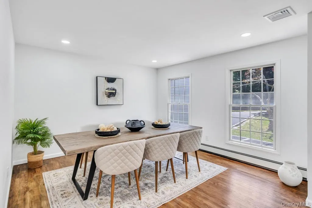 Dining area featuring wood-finish flooring, two large multi-pane windows, recessed lighting, and a neutral color palette Dining area featuring wood-finish flooring, two large multi-pane windows, recessed lighting, and a neutral color palette