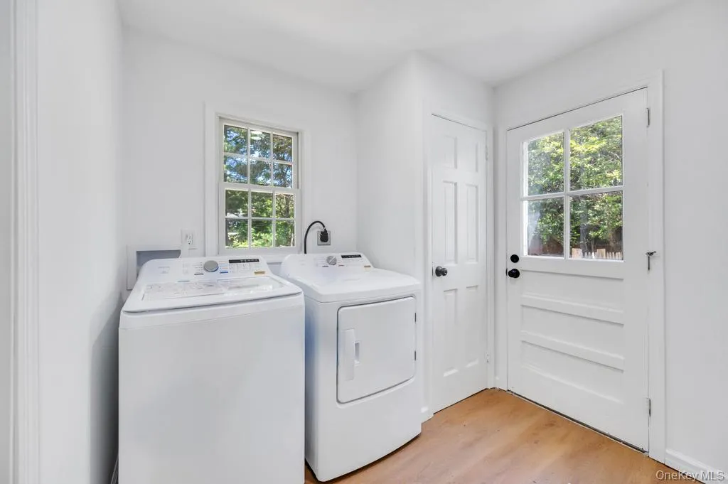 Utility space featuring wood-finish flooring, a multi-pane window, and a glass-paneled door Utility space featuring wood-finish flooring, a multi-pane window, and a glass-paneled door