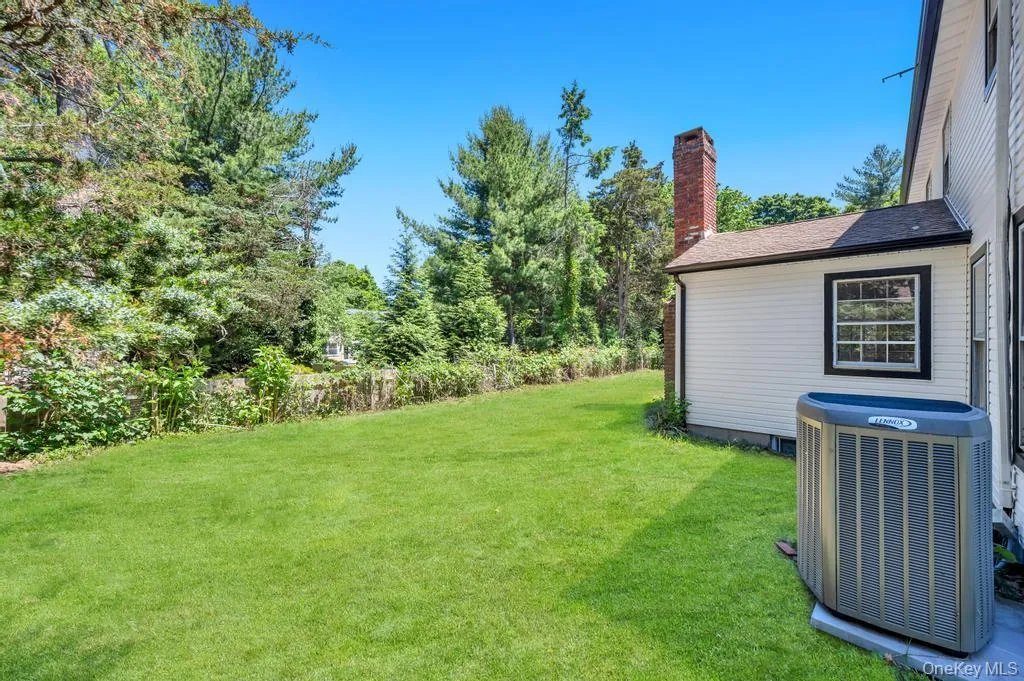 Expansive rear yard featuring a manicured lawn and mature perimeter trees Expansive rear yard featuring a manicured lawn and mature perimeter trees