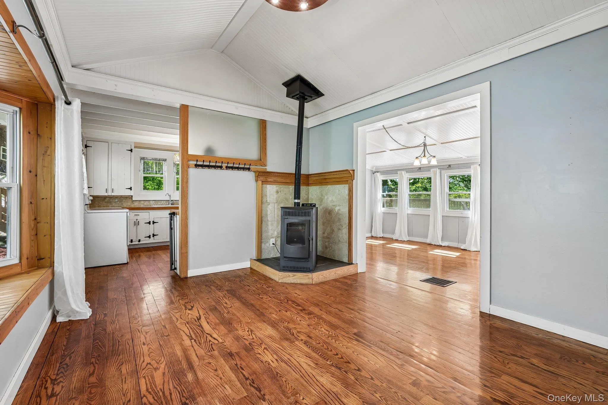 House 2 - Living room with cathedral ceiling, ceiling fan, hardwood floors and pellet stove fireplace. House 2 - Living room with cathedral ceiling, ceiling fan, hardwood floors and pellet stove fireplace.