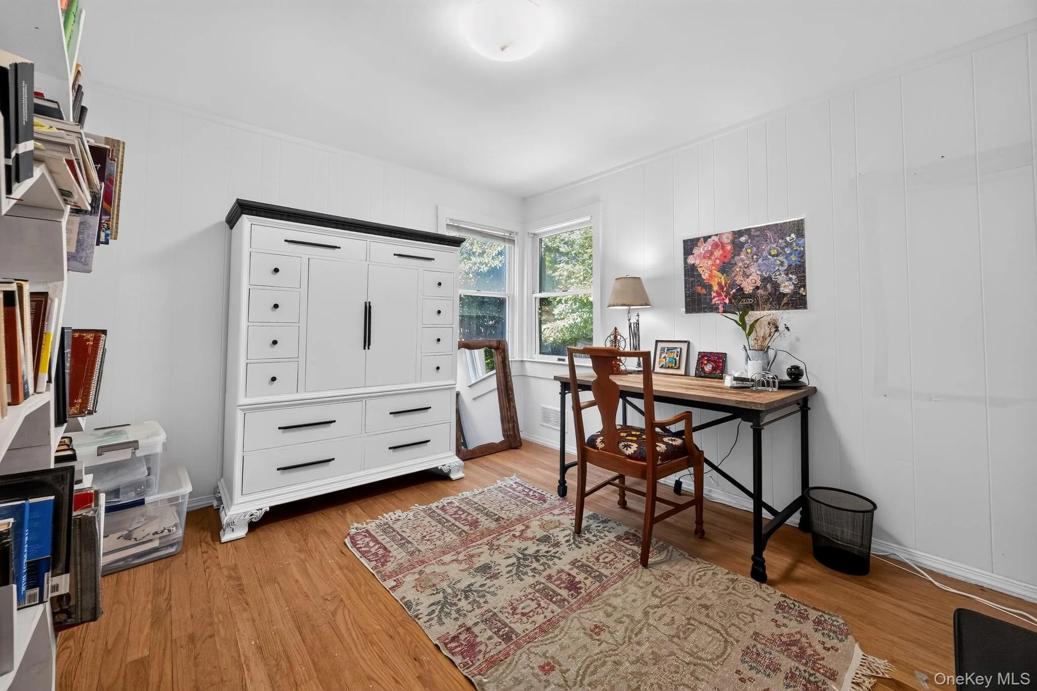 Wood-finish flooring, white paneling, and an overhead light fixture Wood-finish flooring, white paneling, and an overhead light fixture