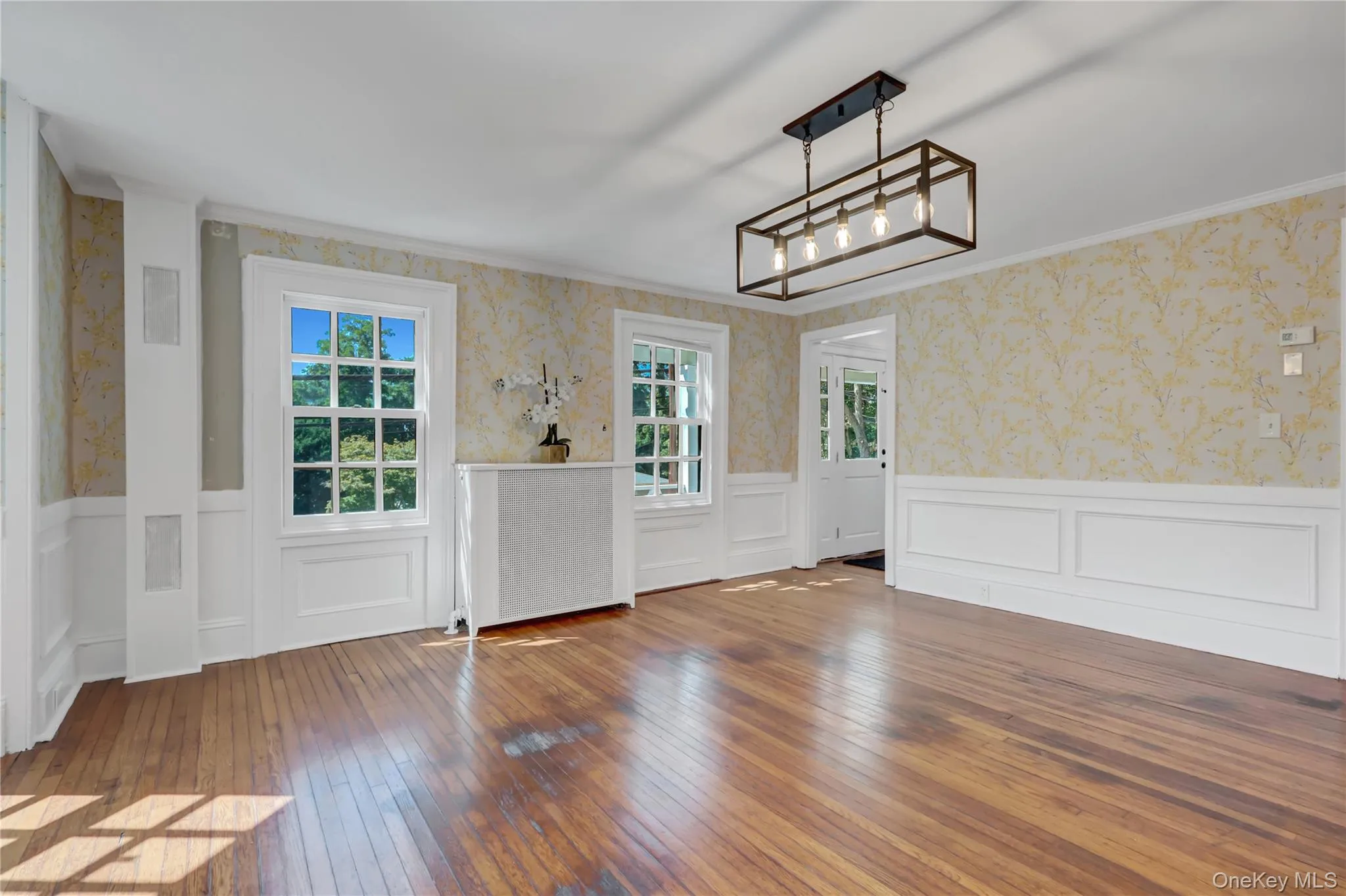 Foyer with wallpapered walls, hardwood / wood-style flooring, wainscoting, and ornamental molding Foyer with wallpapered walls, hardwood / wood-style flooring, wainscoting, and ornamental molding