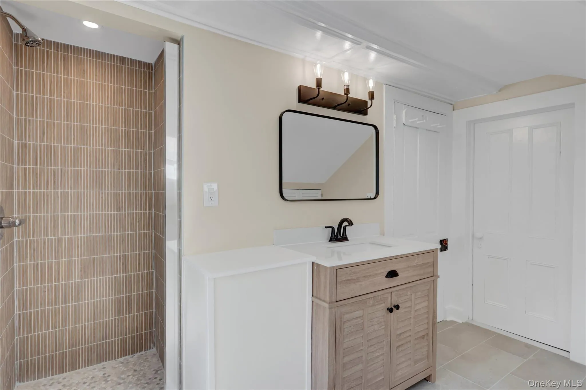 Bathroom with a shower stall, vanity, and light tile patterned floors Bathroom with a shower stall, vanity, and light tile patterned floors