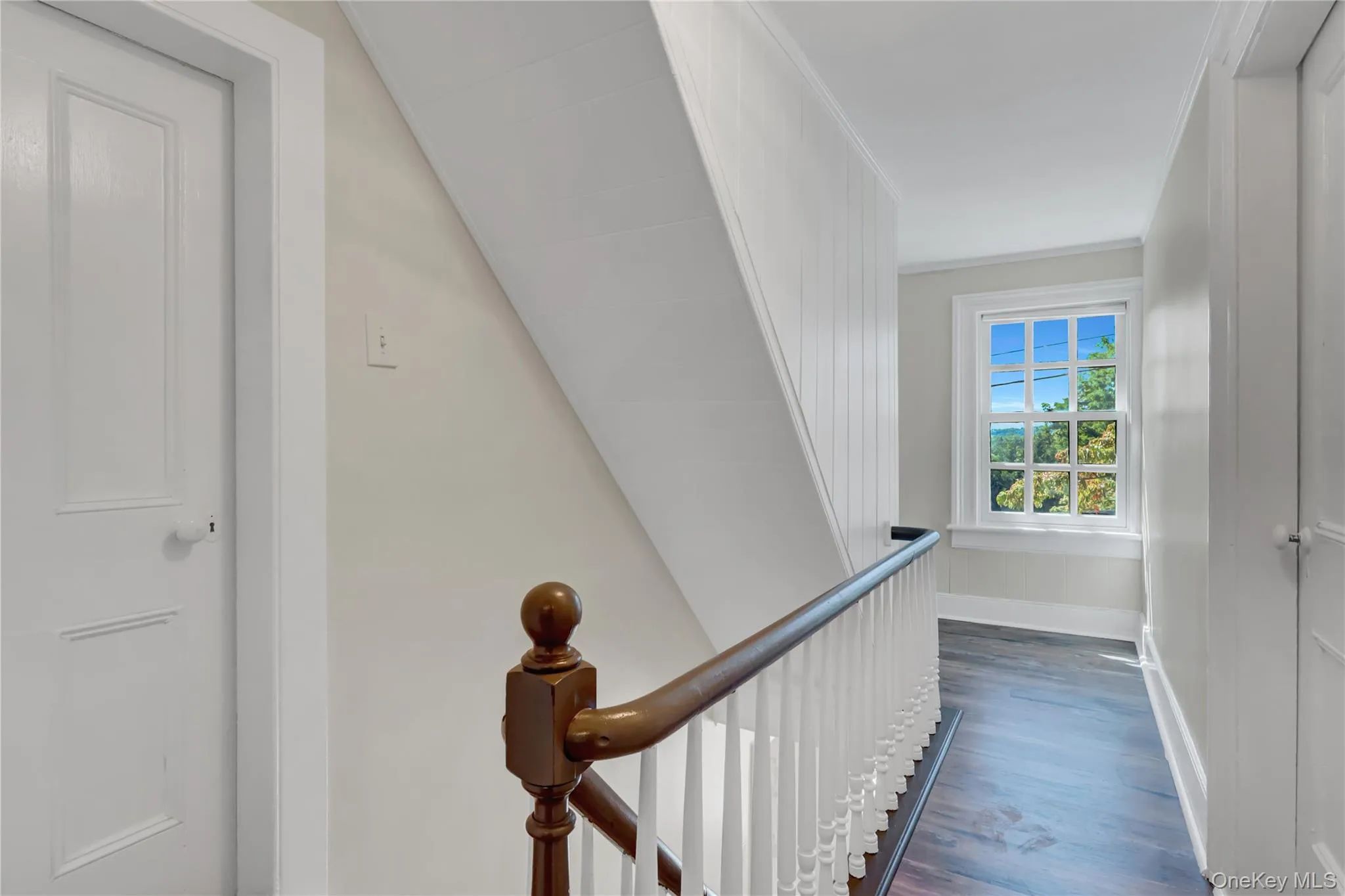 Hall with dark wood-type flooring, ornamental molding, and an upstairs landing Hall with dark wood-type flooring, ornamental molding, and an upstairs landing