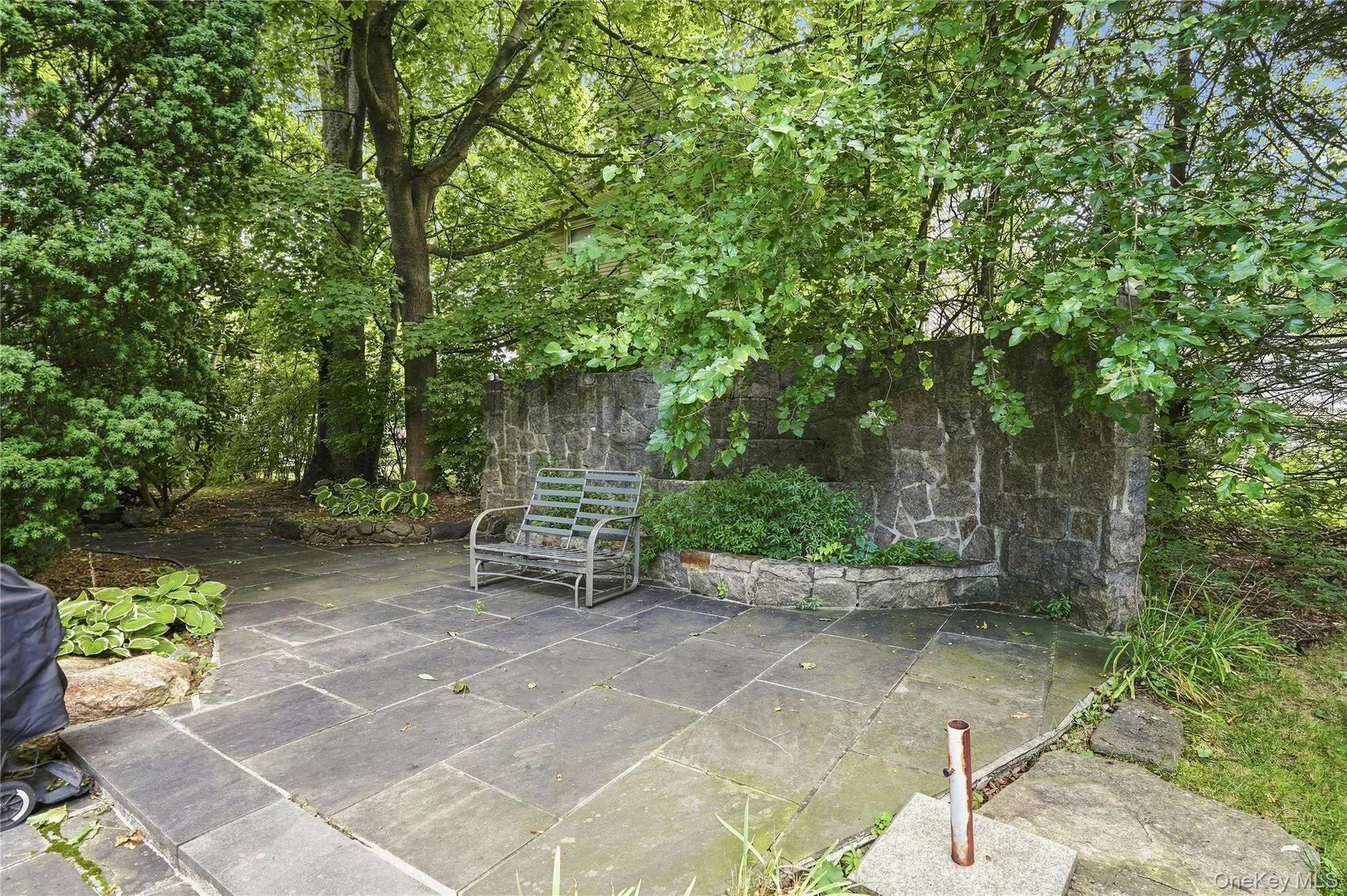 Shaded stone patio creates a peaceful backyard retreat Shaded stone patio creates a peaceful backyard retreat