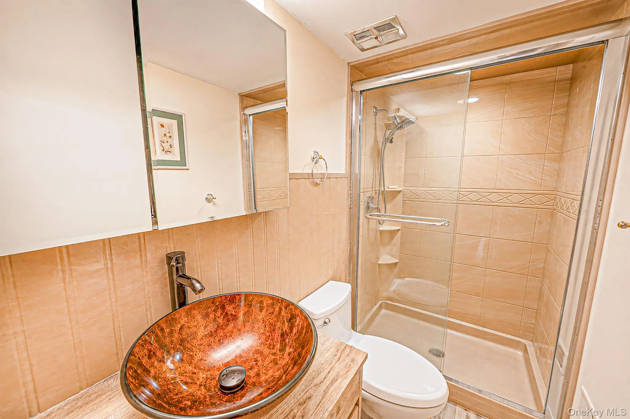 Glass-enclosed shower with tiled walls and decorative accent band Glass-enclosed shower with tiled walls and decorative accent band