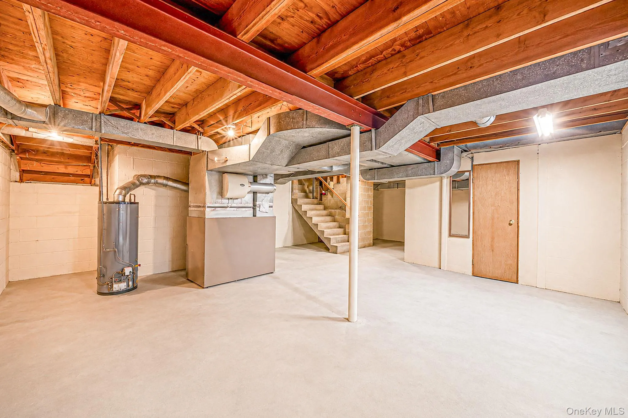 Unfinished basement with exposed ceiling joists, concrete flooring, and solid wood interior doors Unfinished basement with exposed ceiling joists, concrete flooring, and solid wood interior doors