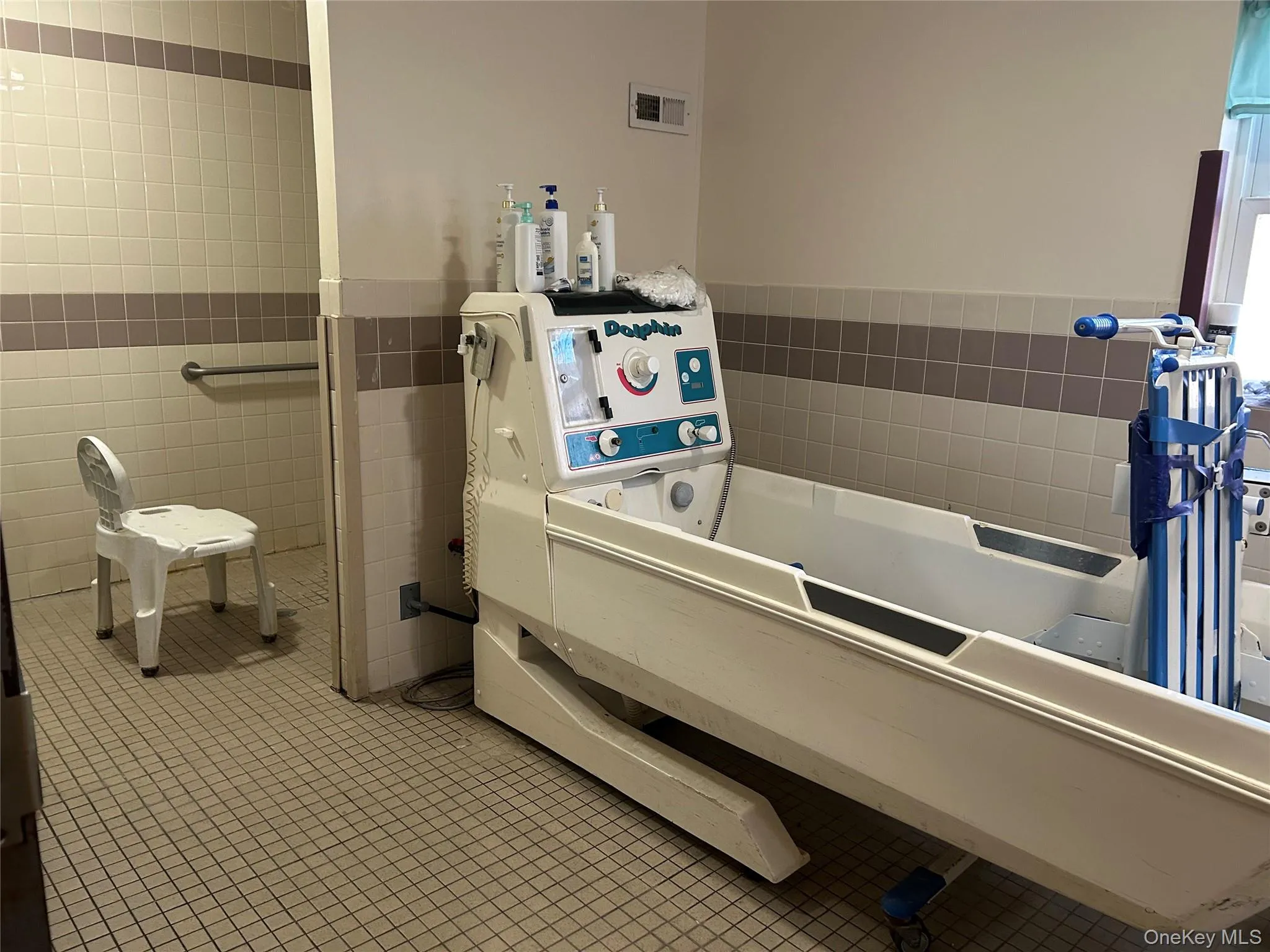 Full bathroom with tile walls, a bath, and wainscoting Full bathroom with tile walls, a bath, and wainscoting