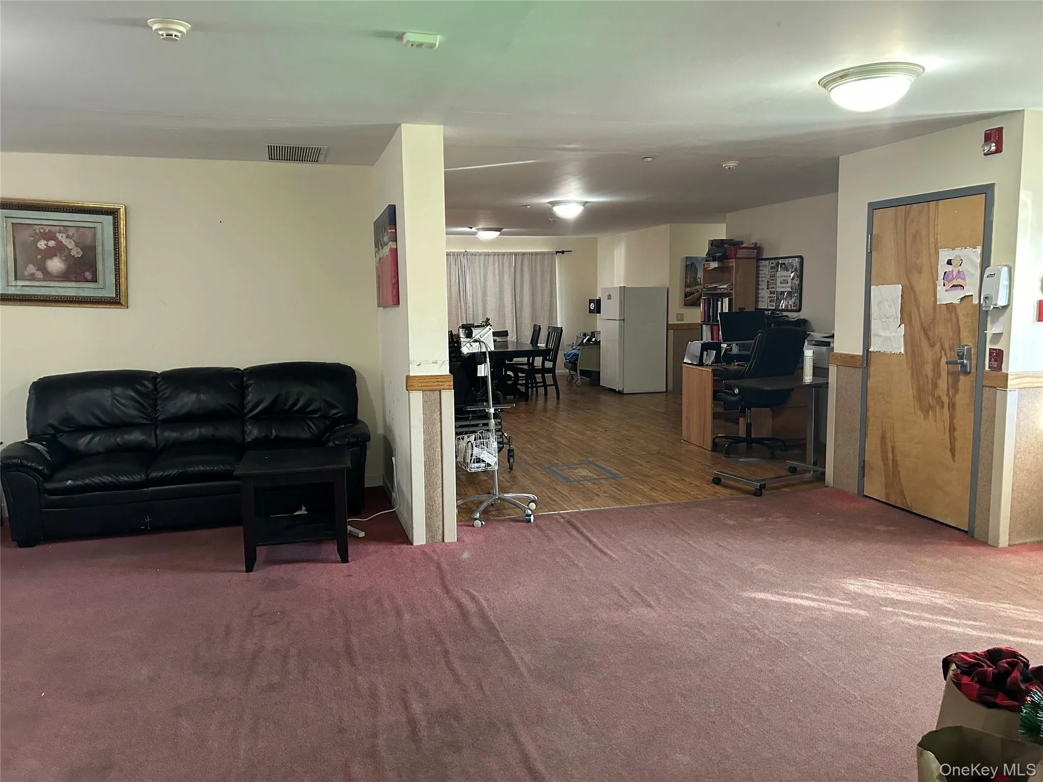 Living room with a desk and carpet floors Living room with a desk and carpet floors