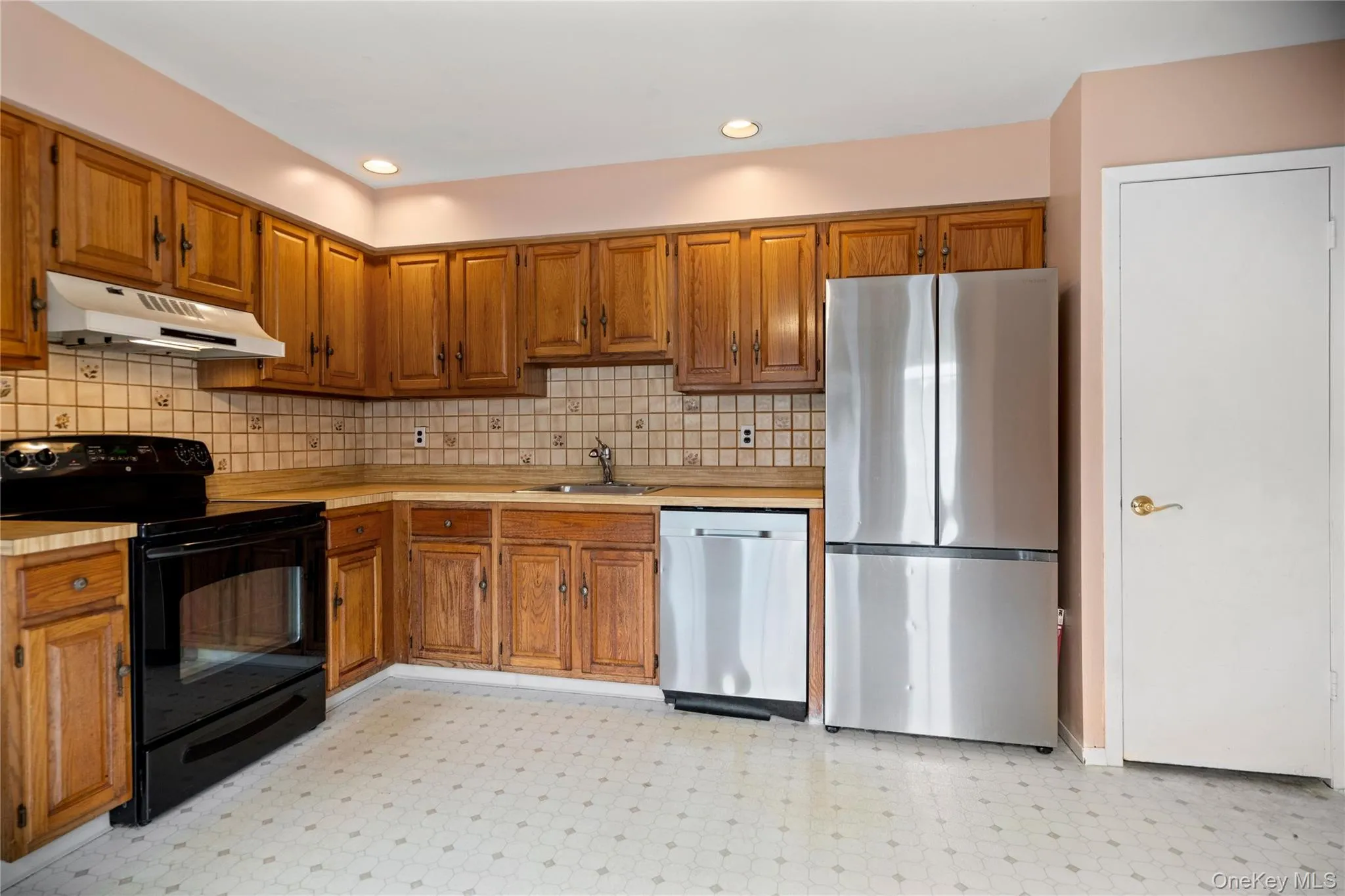 Eat in kitchen with wood cabinets, and tile backsplash. Eat in kitchen with wood cabinets, and tile backsplash.