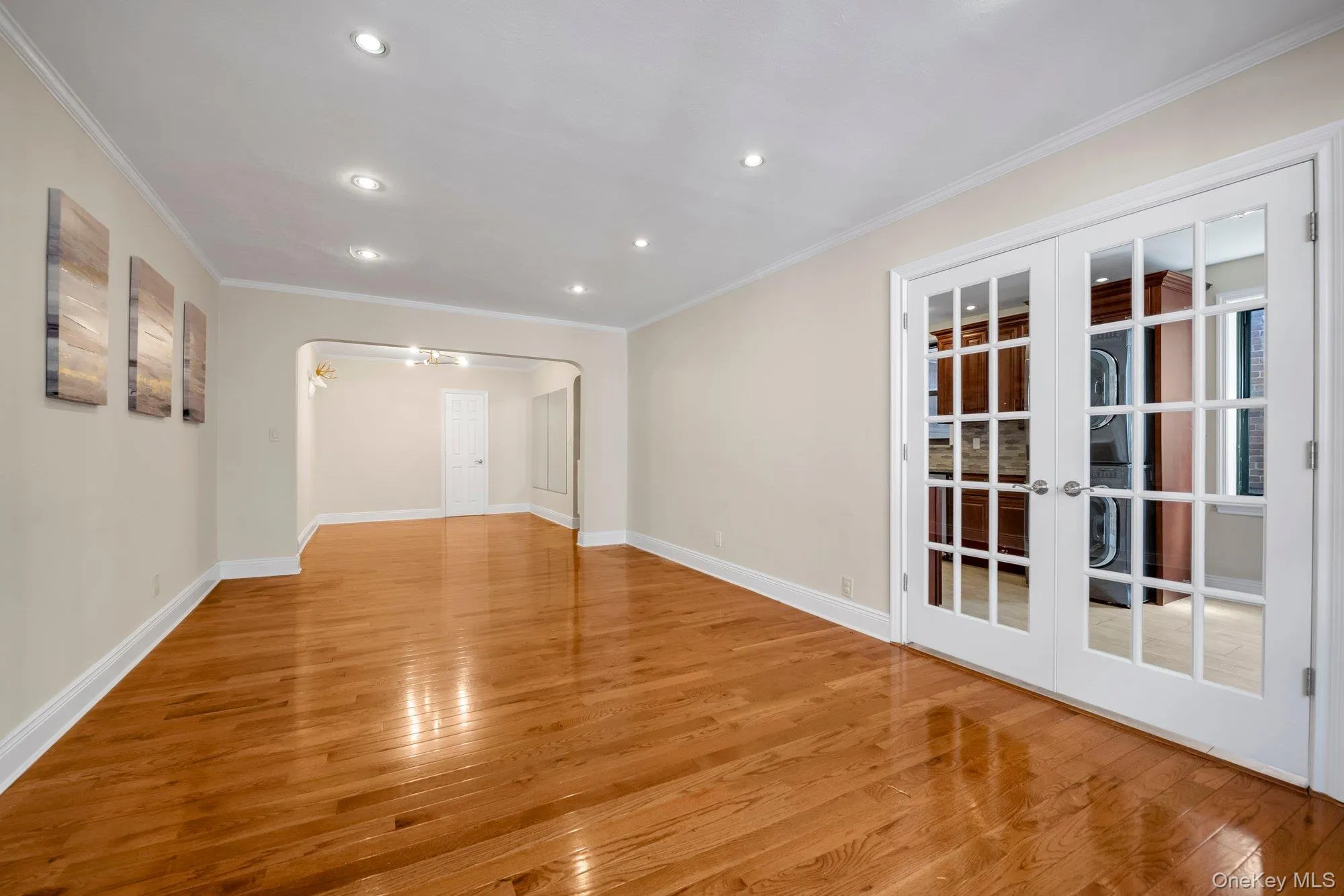 Wood-finish flooring, recessed lighting, and white-trimmed French doors Wood-finish flooring, recessed lighting, and white-trimmed French doors