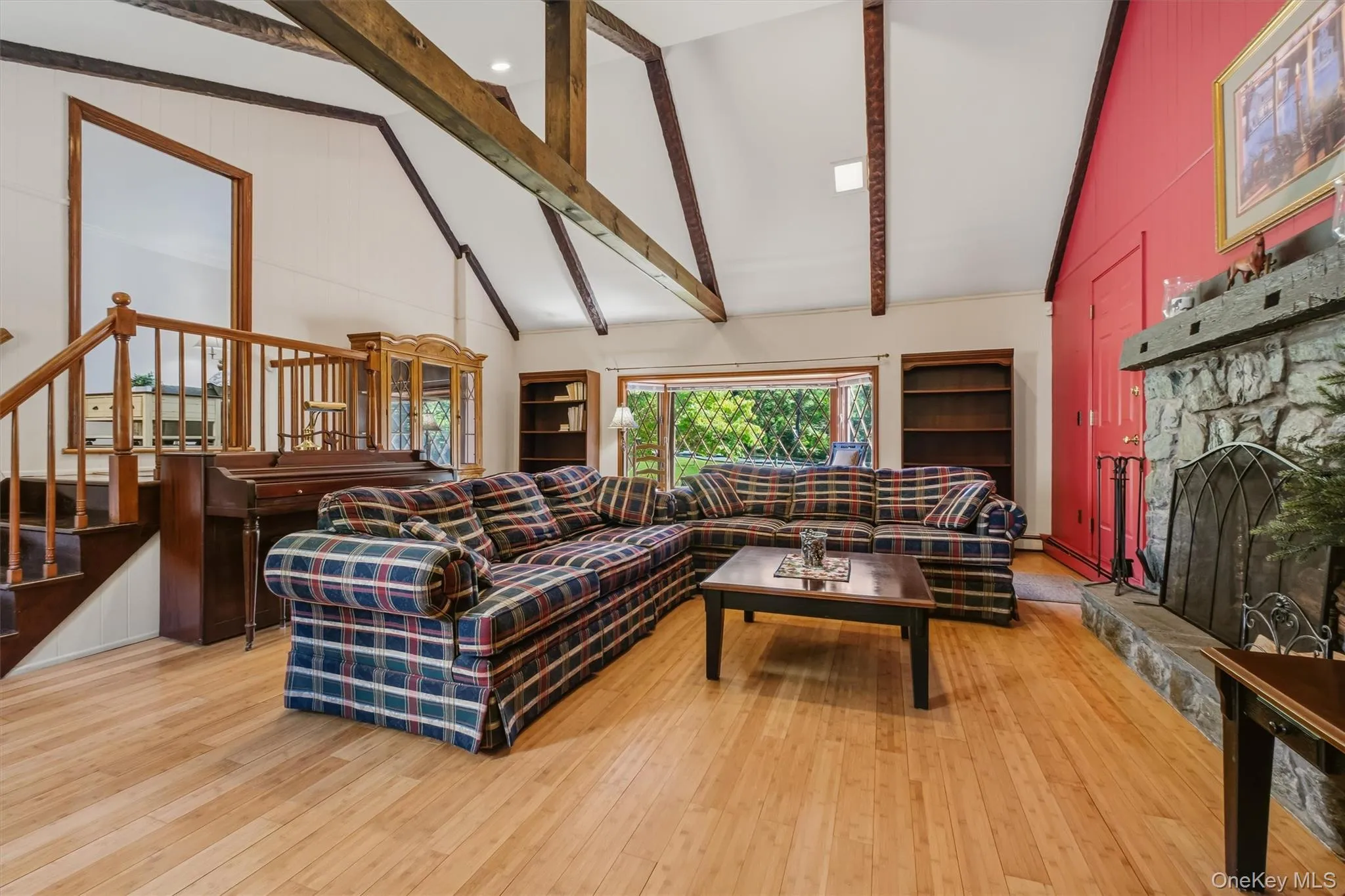 Enormous family room with beamed, cathedral ceiling, bamboo floors, large bay window and stone fireplace Enormous family room with beamed, cathedral ceiling, bamboo floors, large bay window and stone fireplace