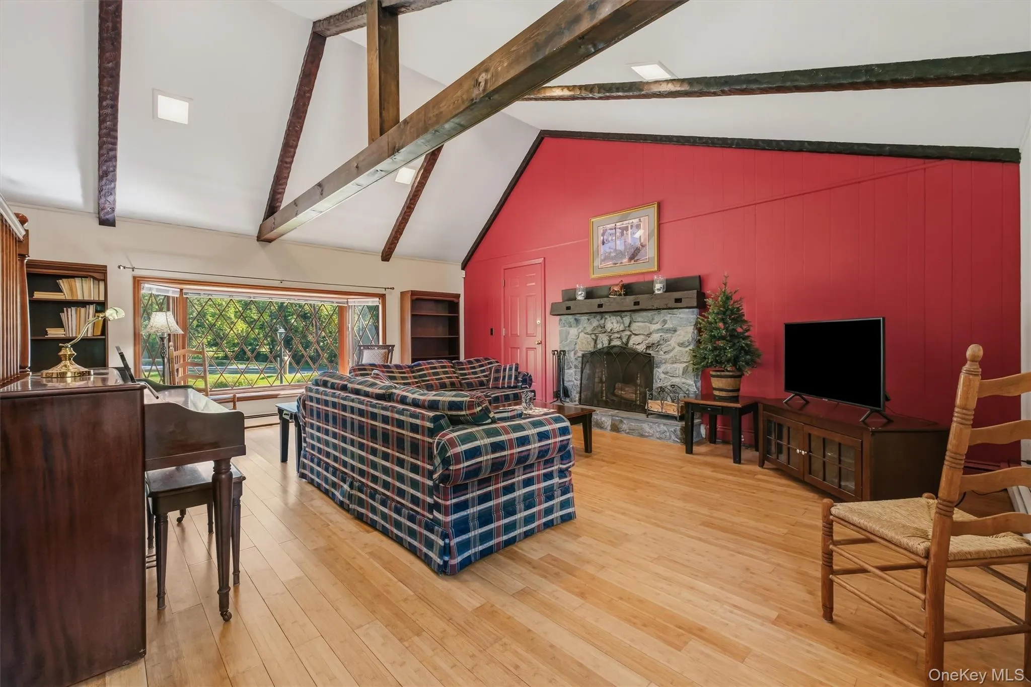 Enormous family room with beamed, cathedral ceiling, bamboo floors, large bay window and stone fireplace Enormous family room with beamed, cathedral ceiling, bamboo floors, large bay window and stone fireplace